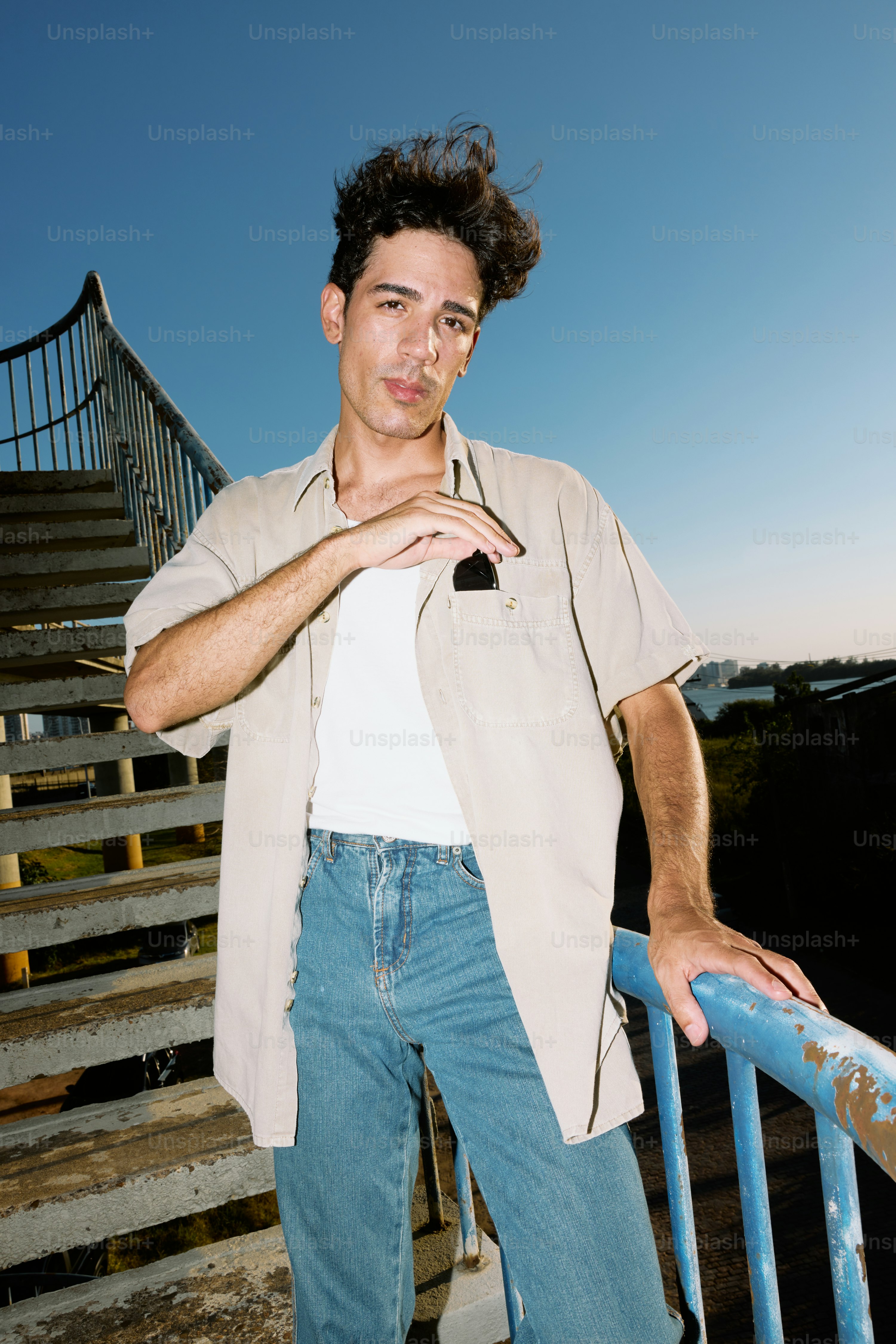 A man leaning on a railing with his hands on his hips