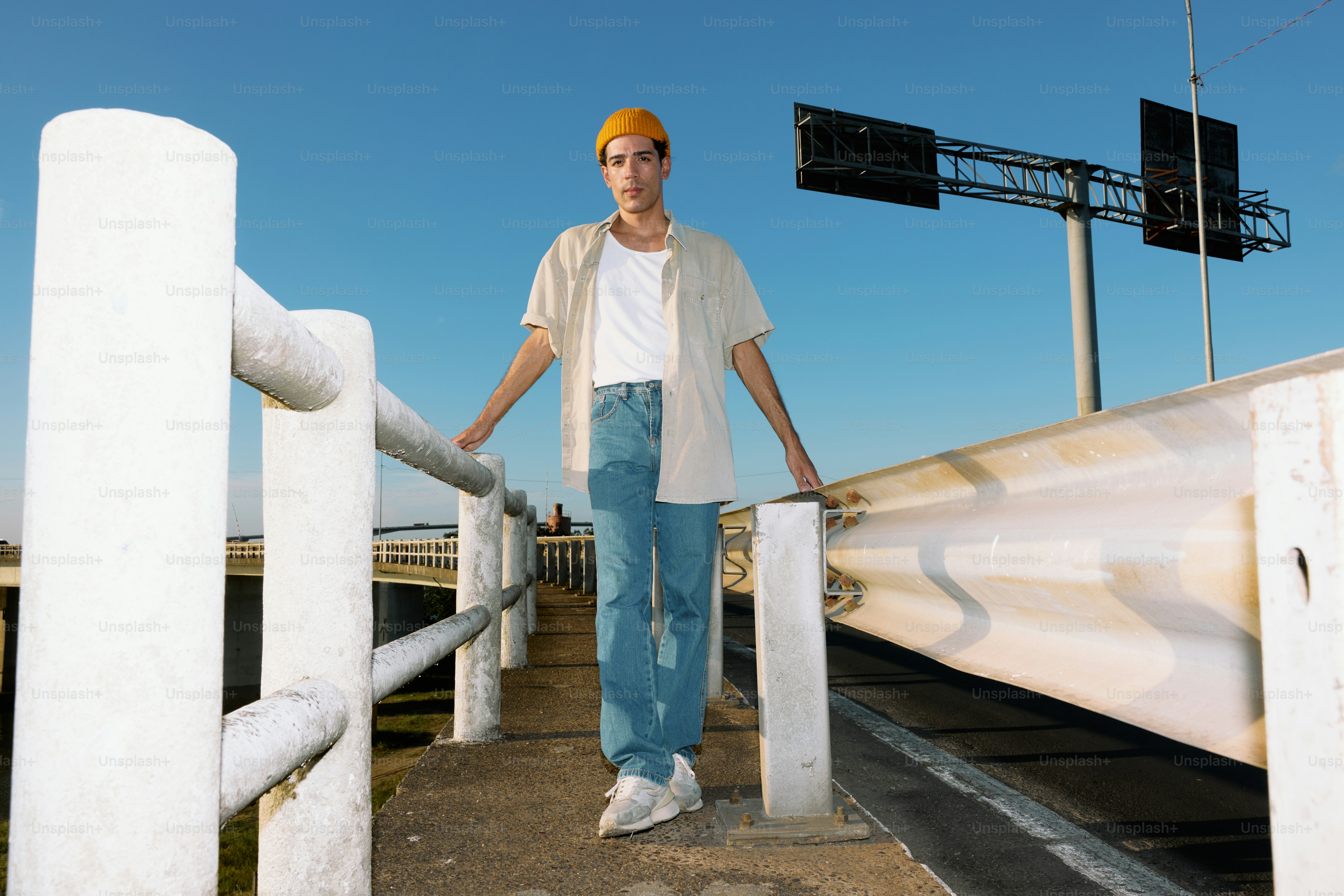 A man standing on a bridge with his hands on his hips