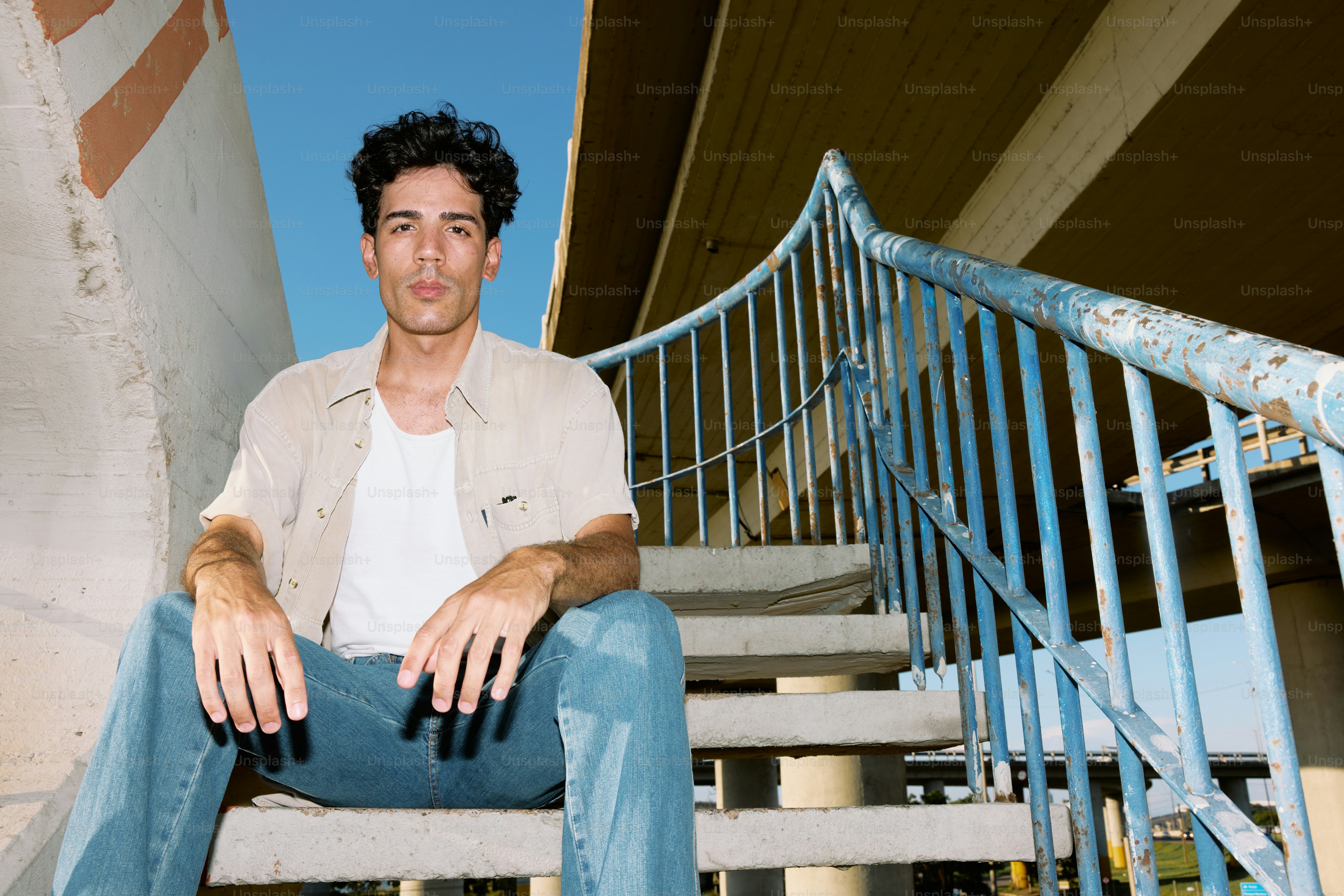 A man sitting on a bench next to a stair case