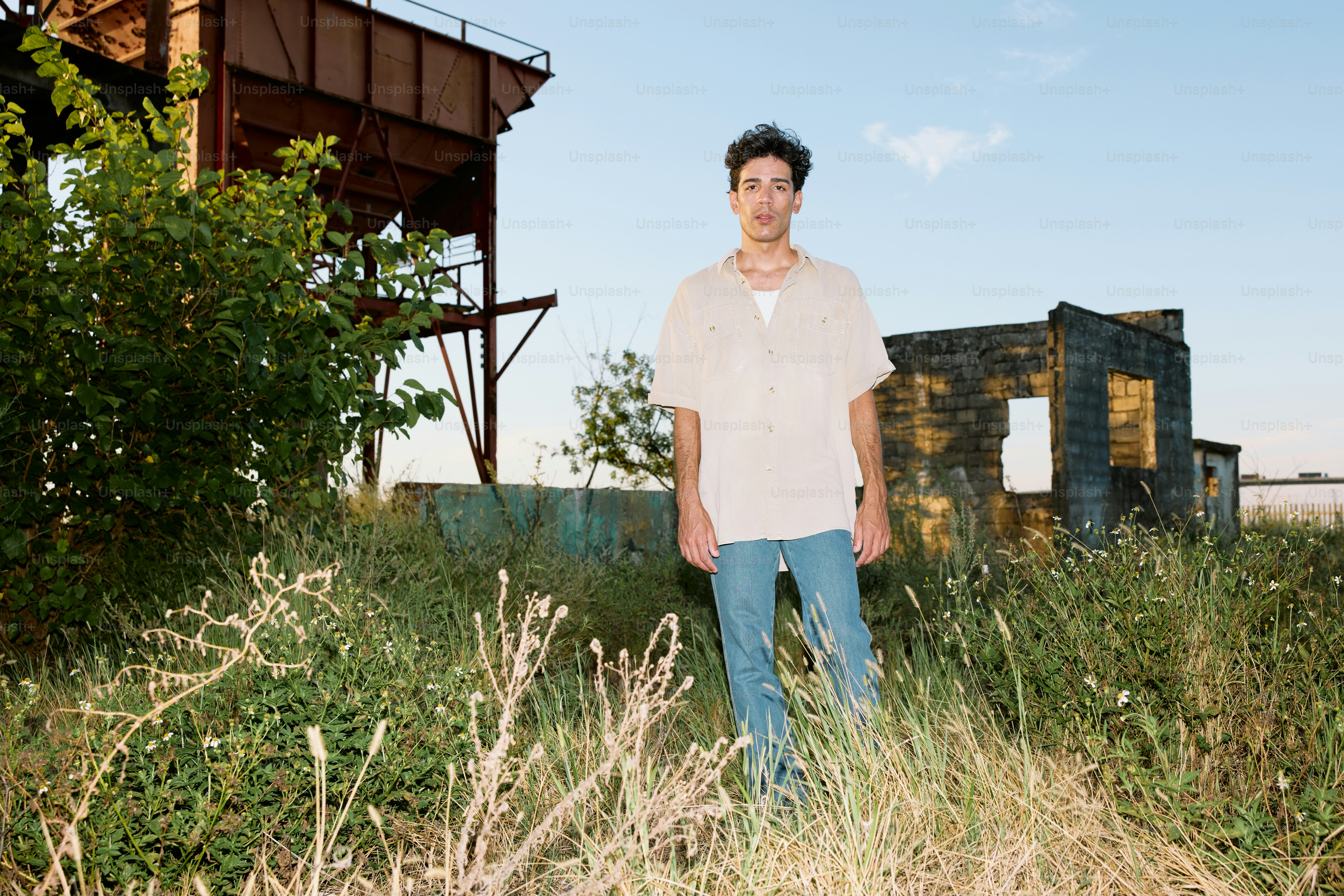 A man standing in a field next to a building