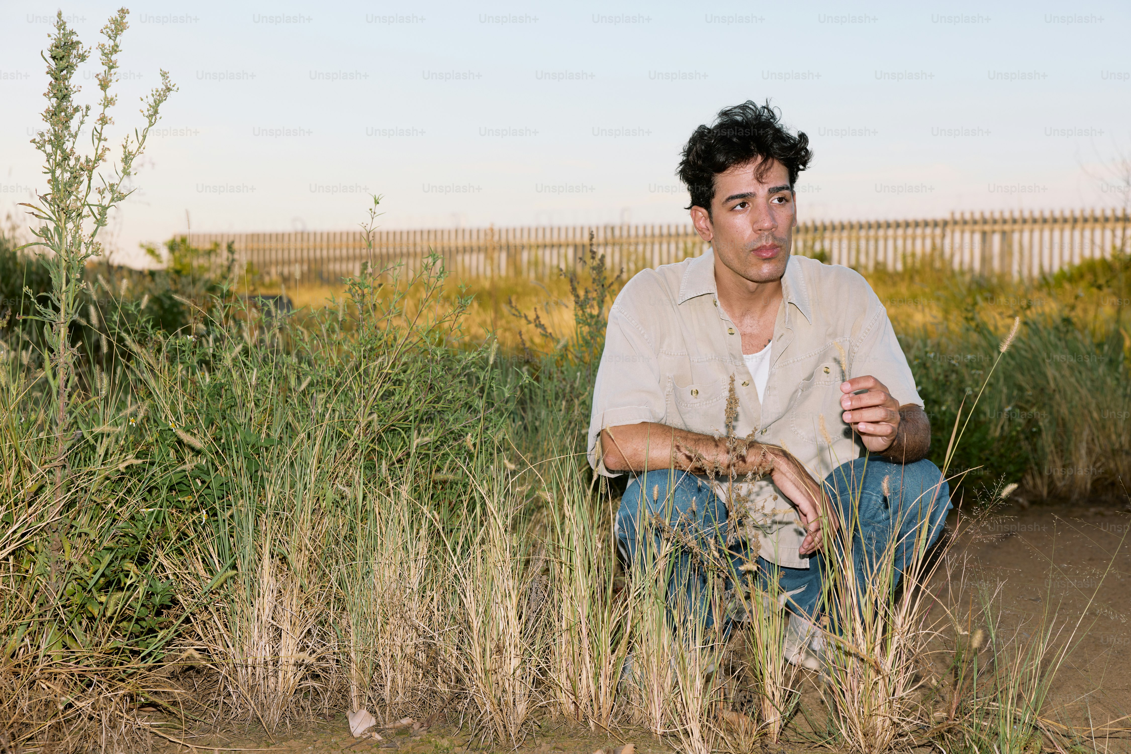 A man sitting in a field of tall grass