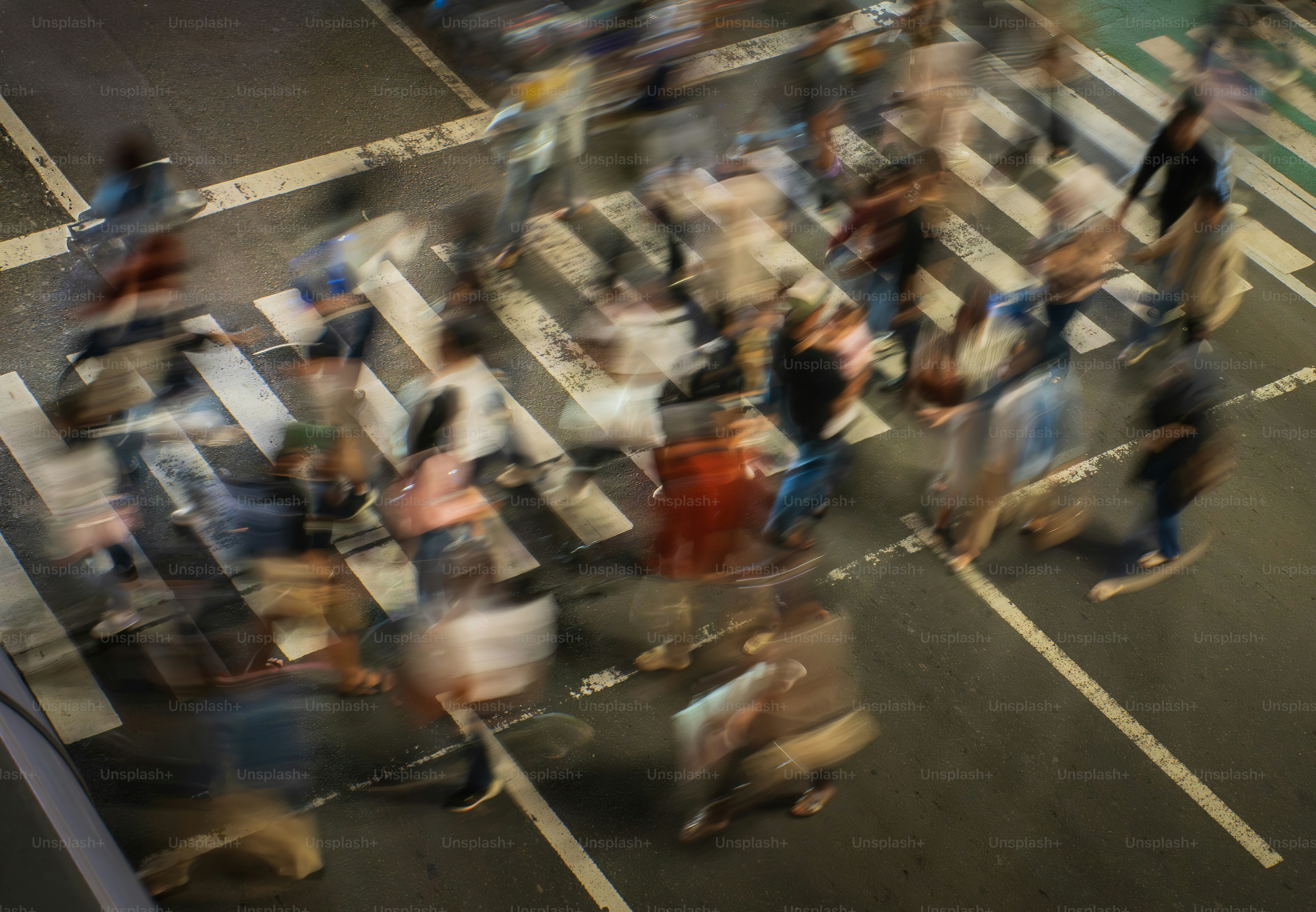 A blurry image of a crowd of people crossing a street