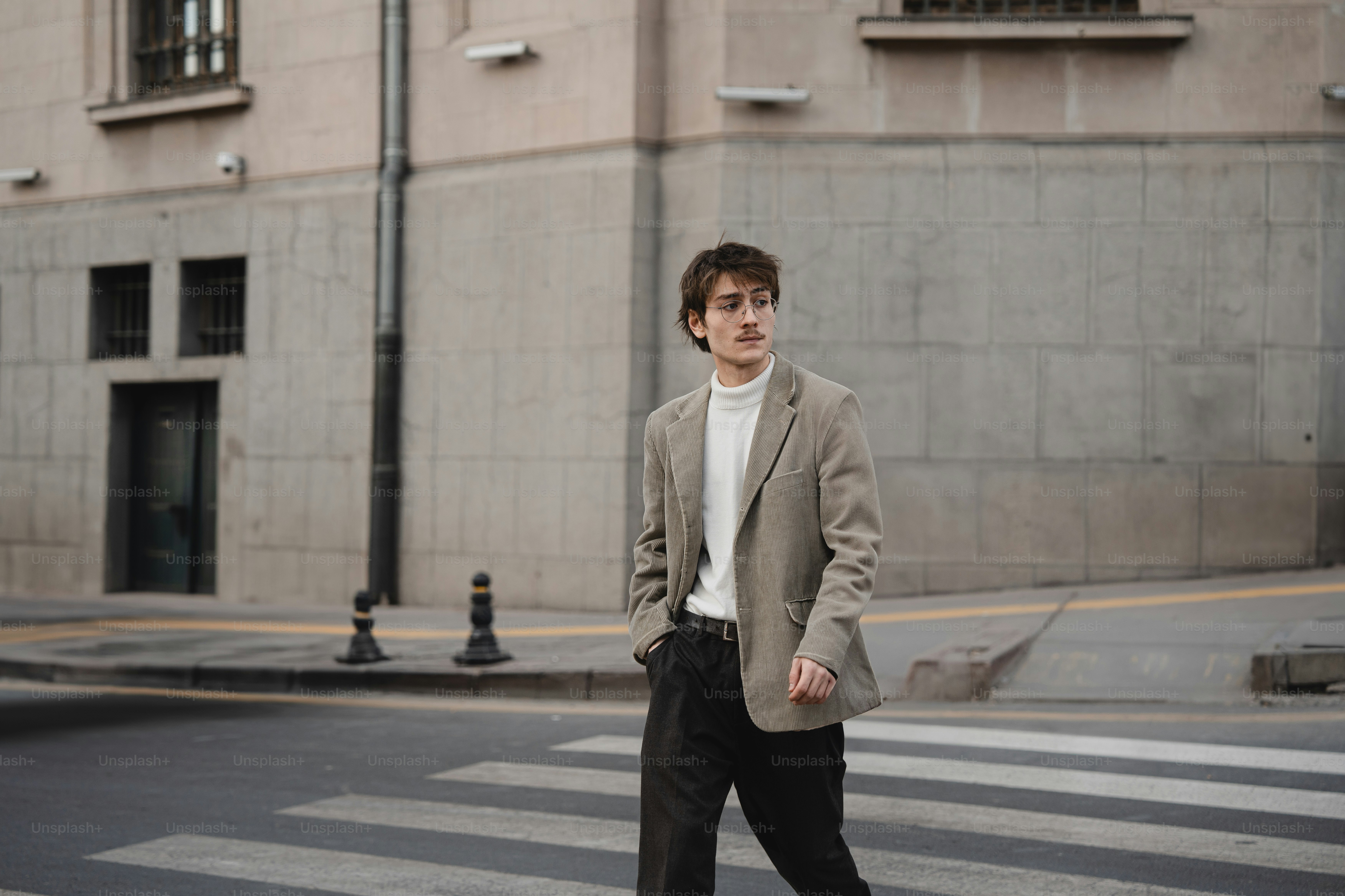 A man crossing the street in front of a building