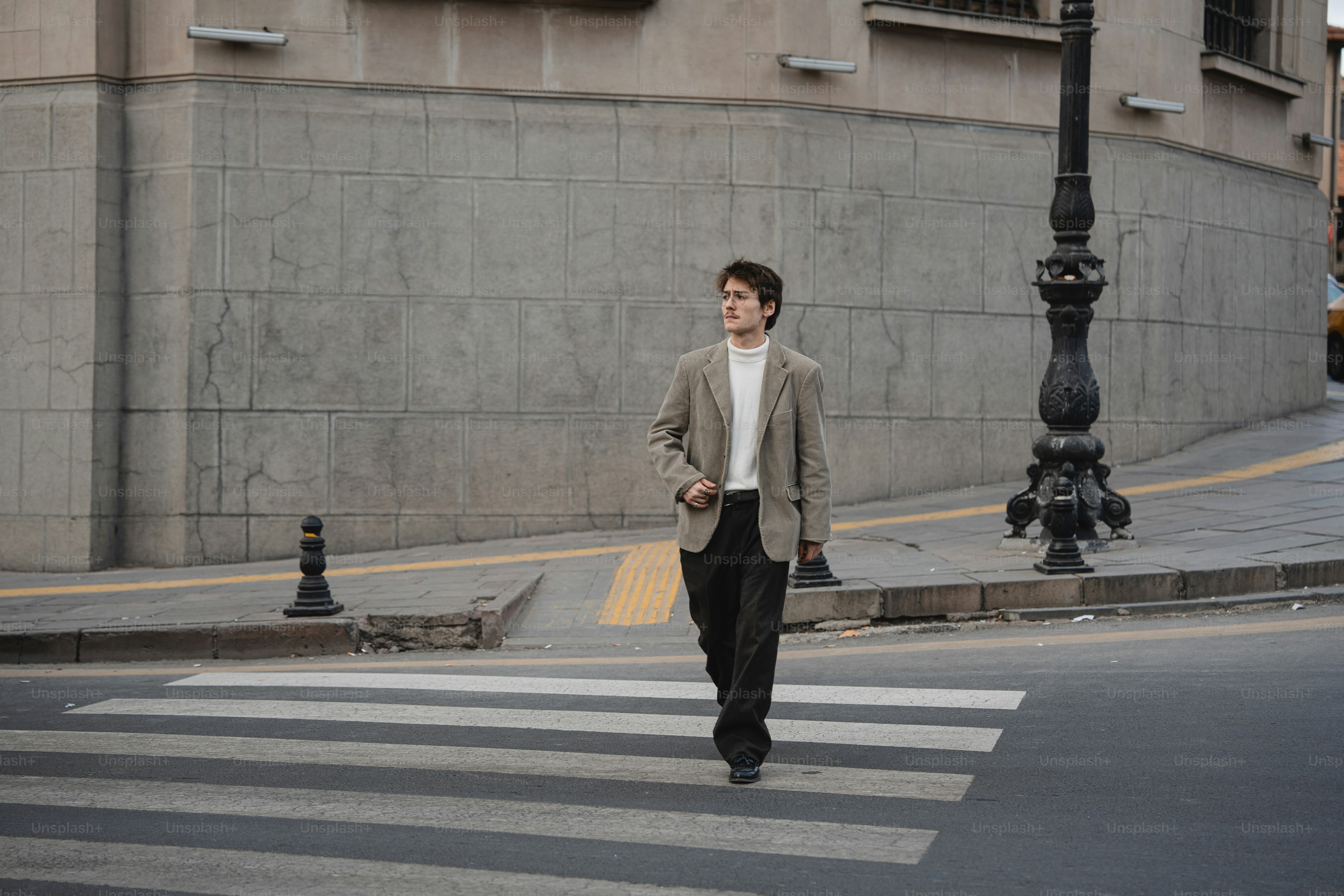 A man walking across a cross walk in a city