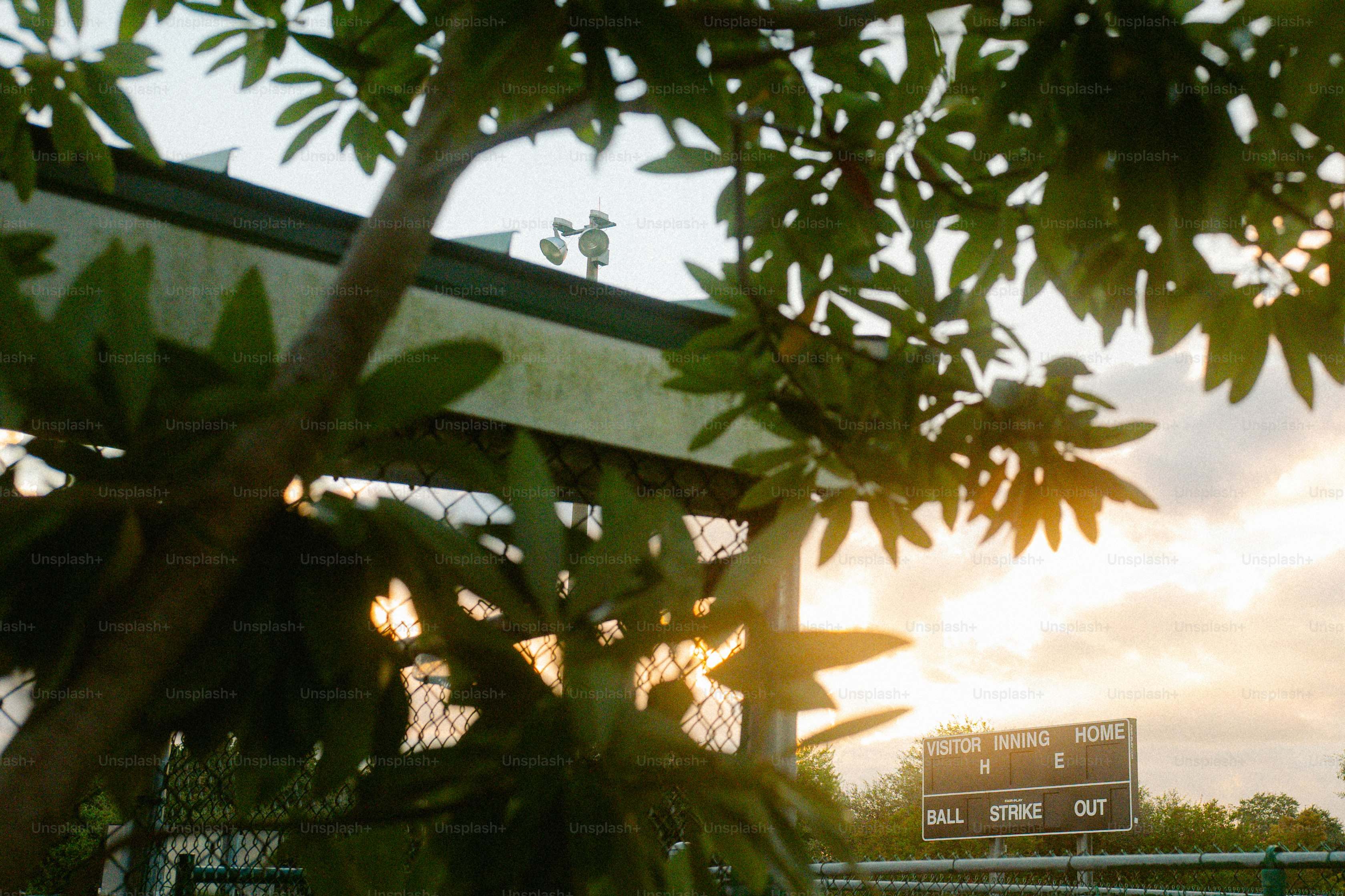 The sun is setting over a baseball field