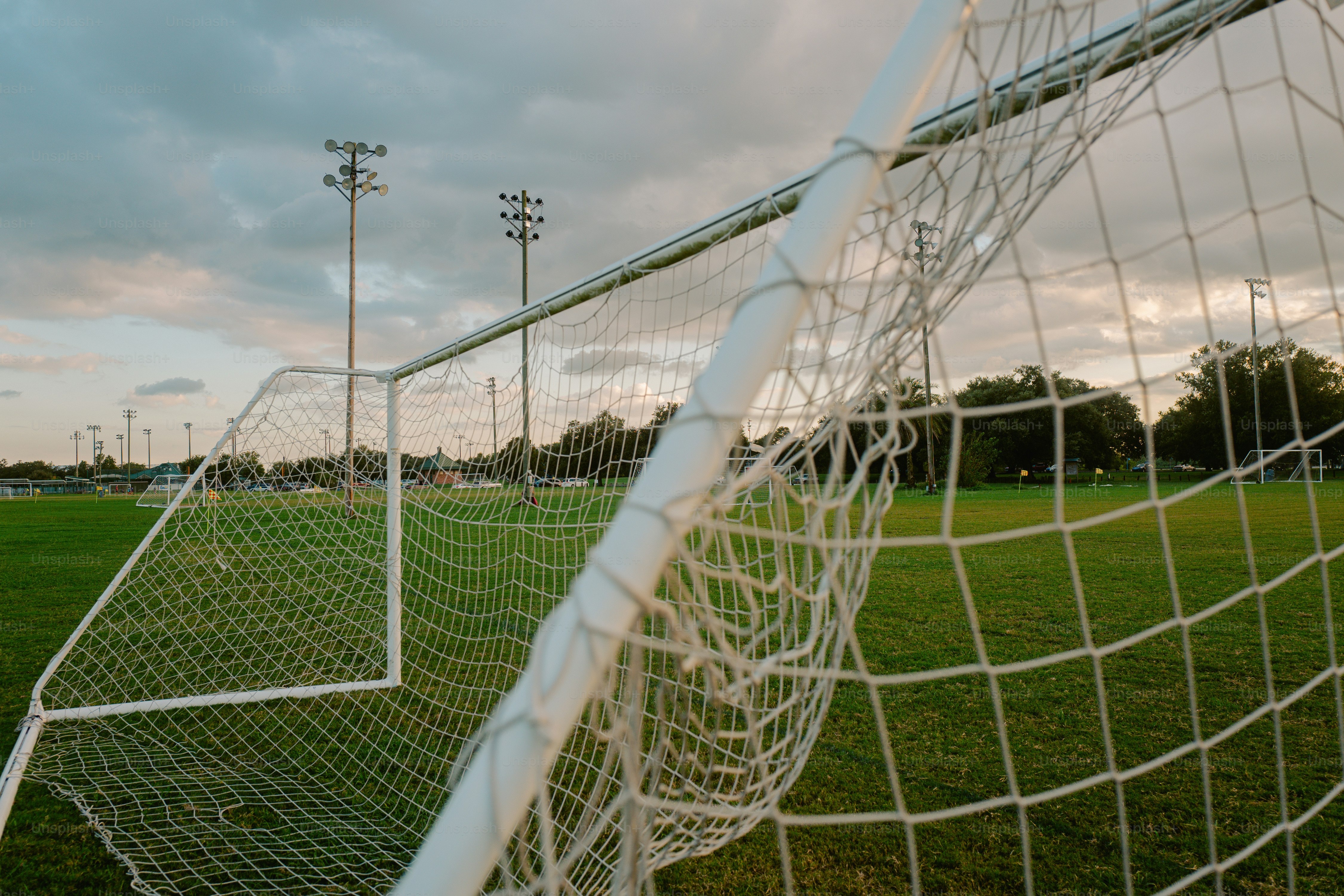 A soccer goal sitting on top of a lush green field