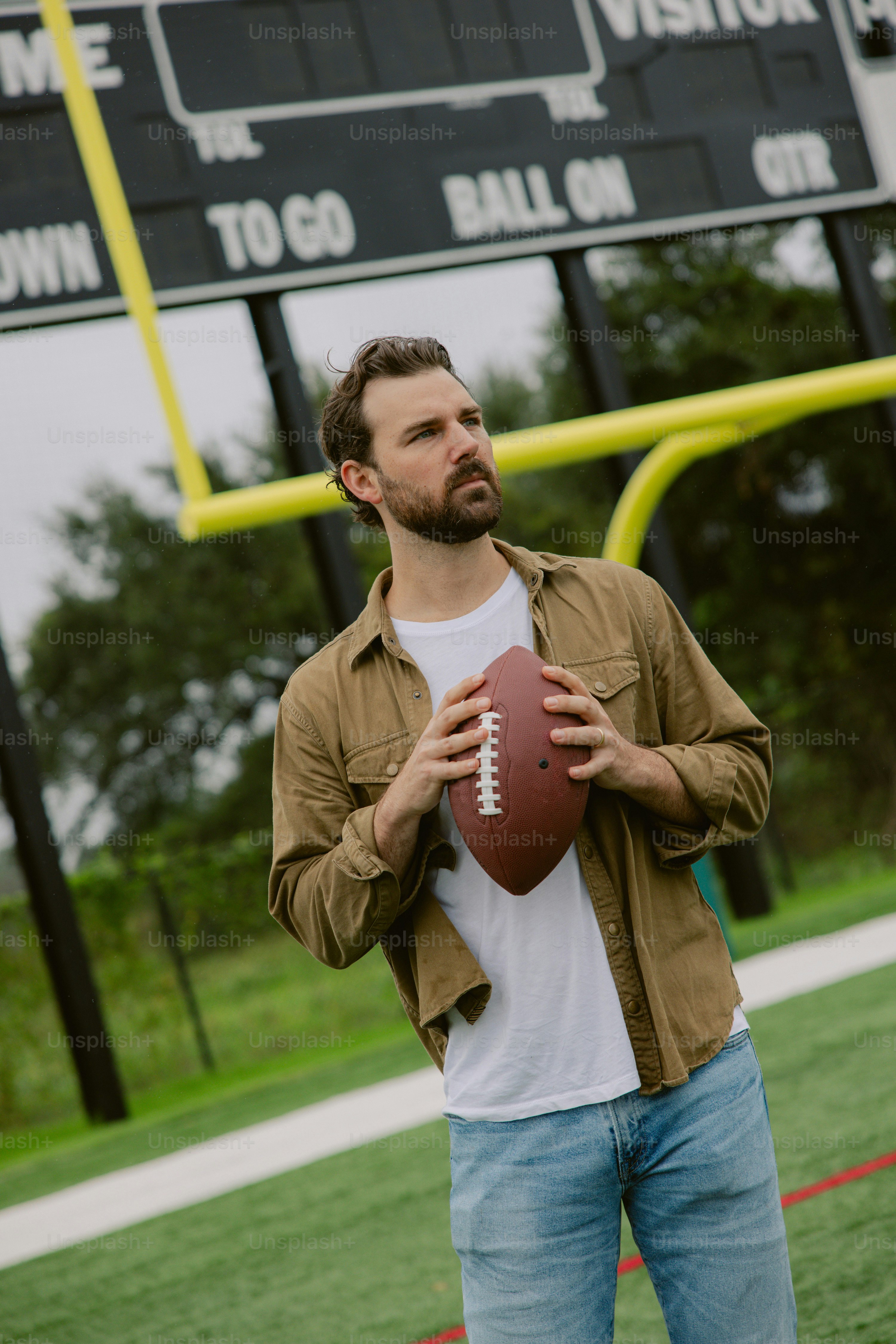 Um homem segurando uma bola de futebol em um campo