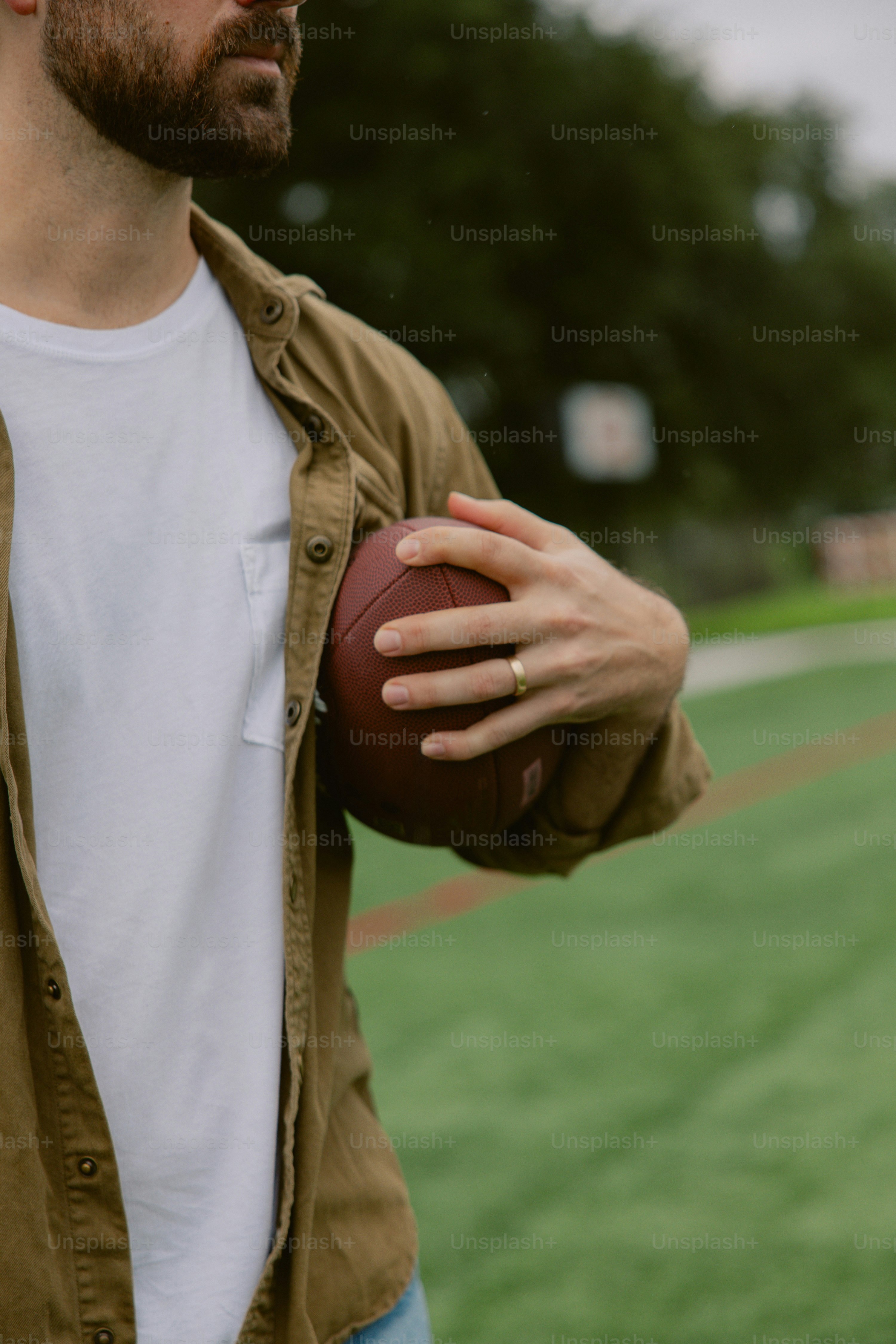 Um homem segurando uma bola de futebol em um campo