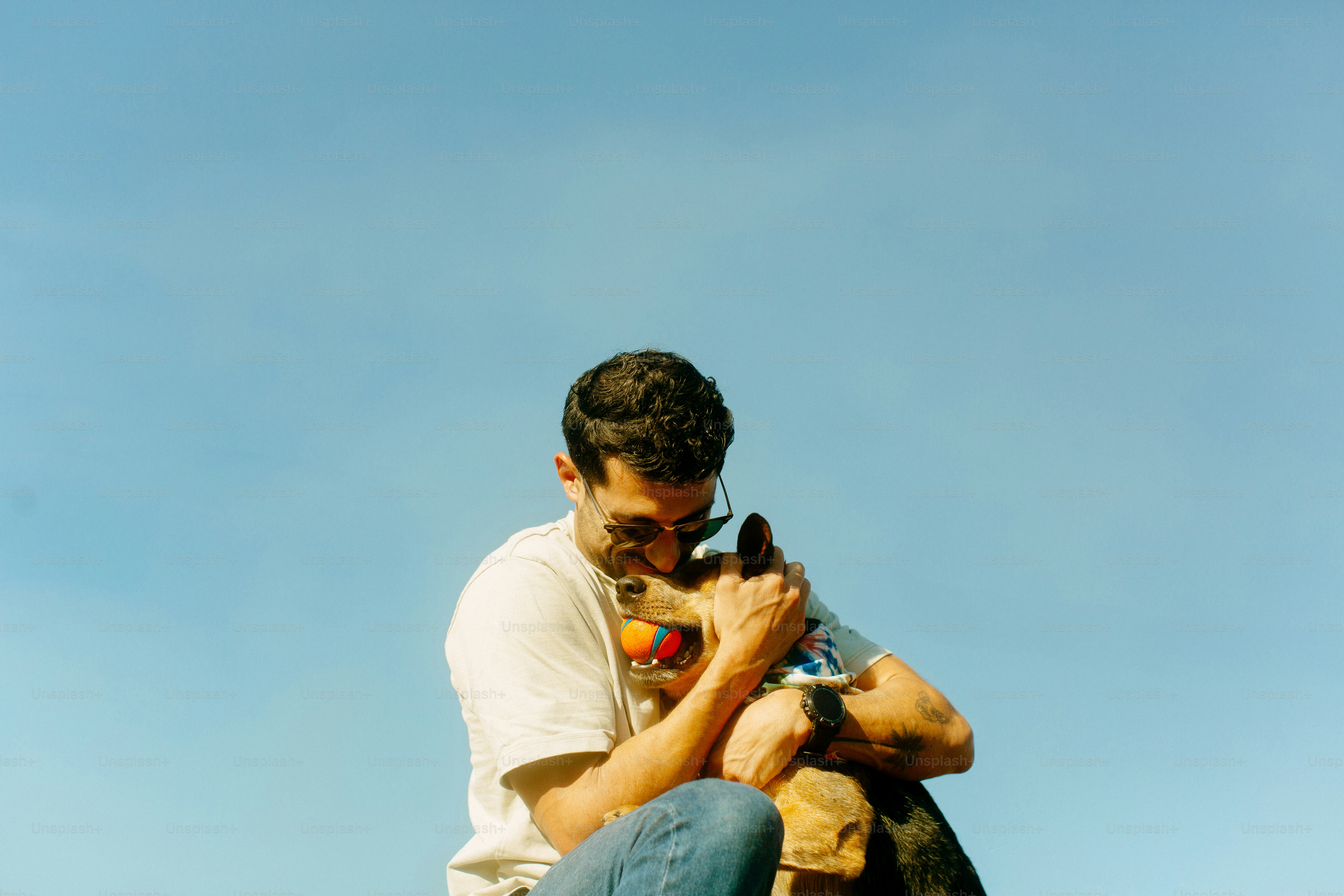 A man sitting on top of a skateboard holding a dog