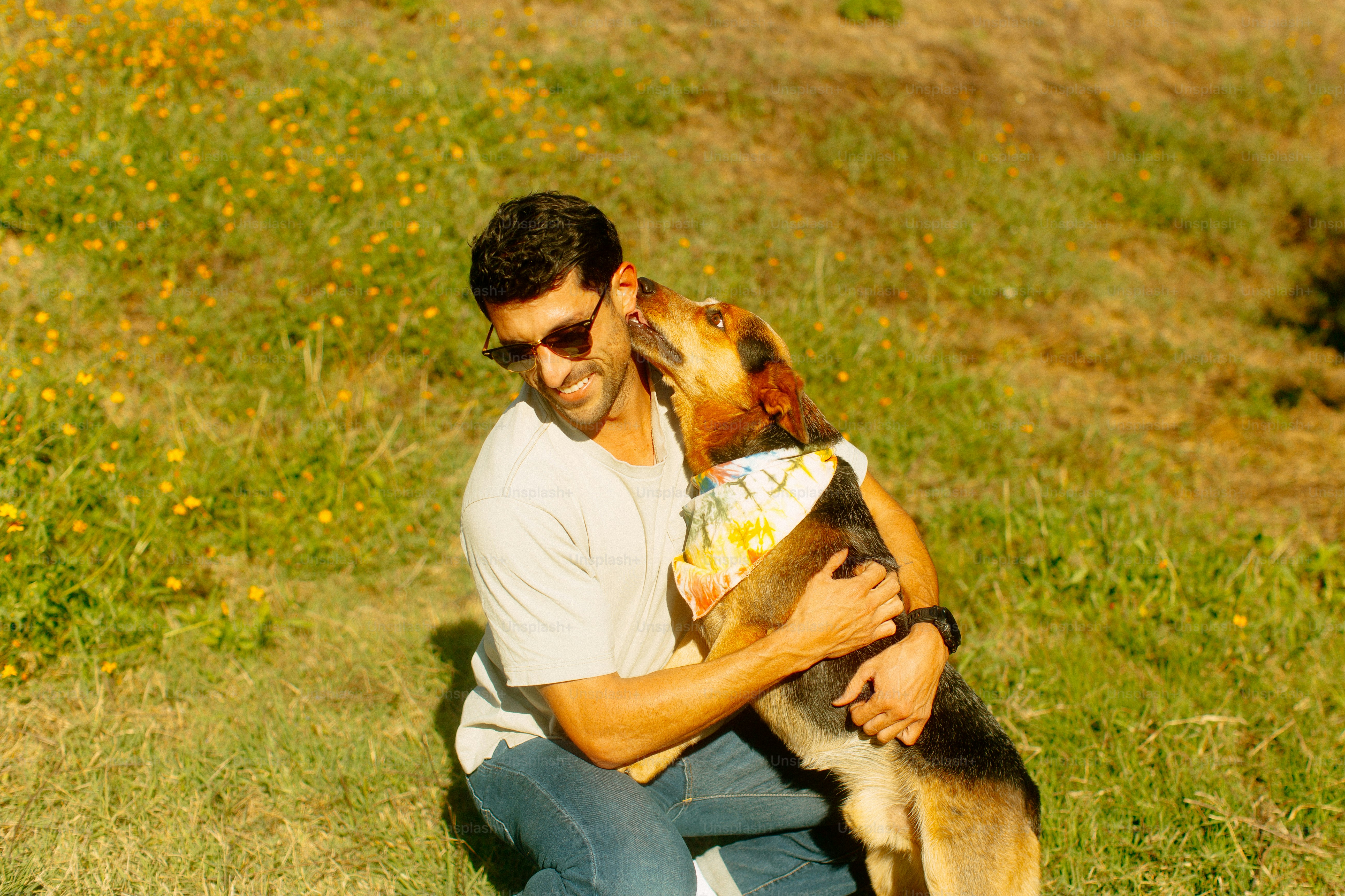 A man sitting on the ground holding a dog