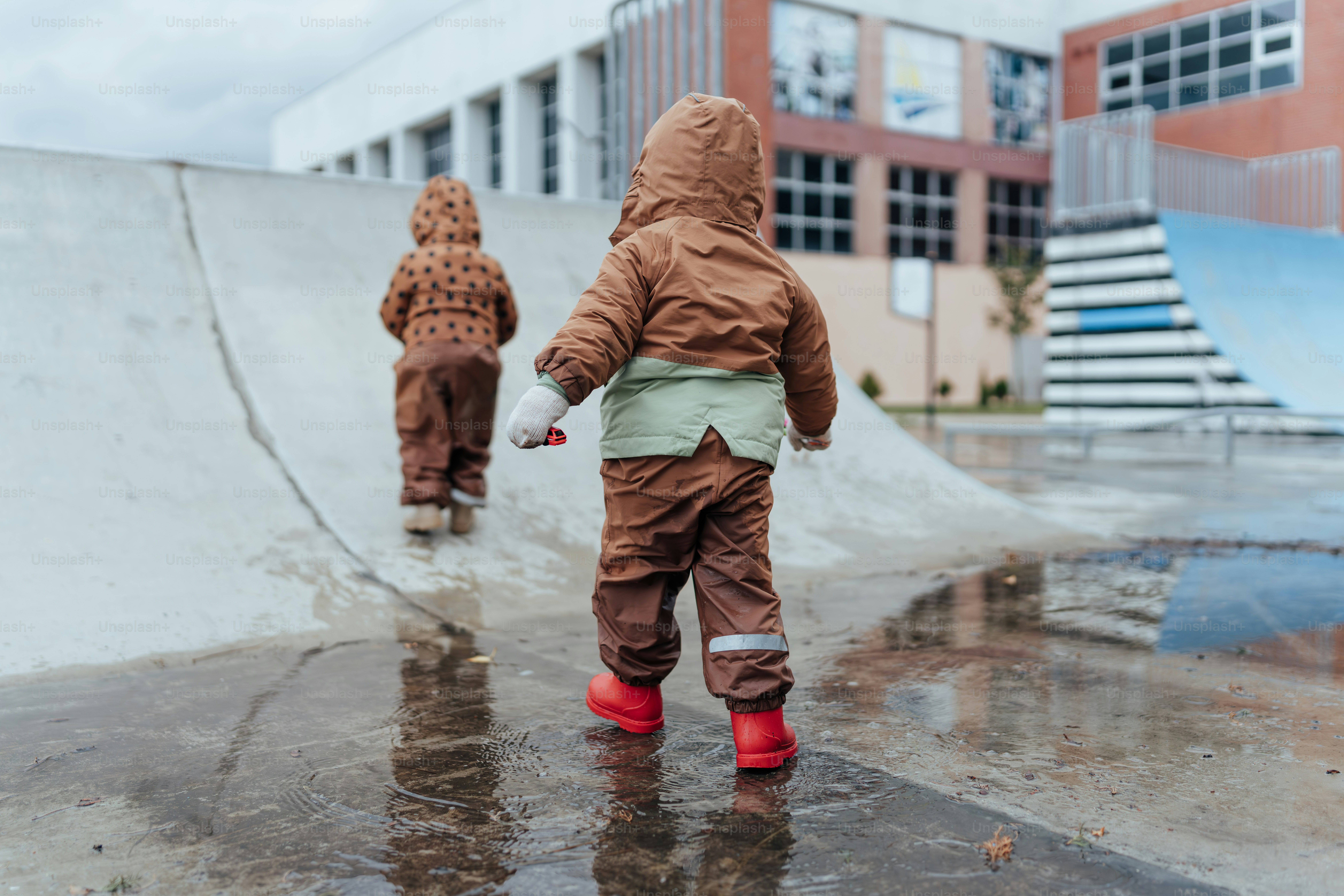 Un par de niños que están parados bajo la lluvia