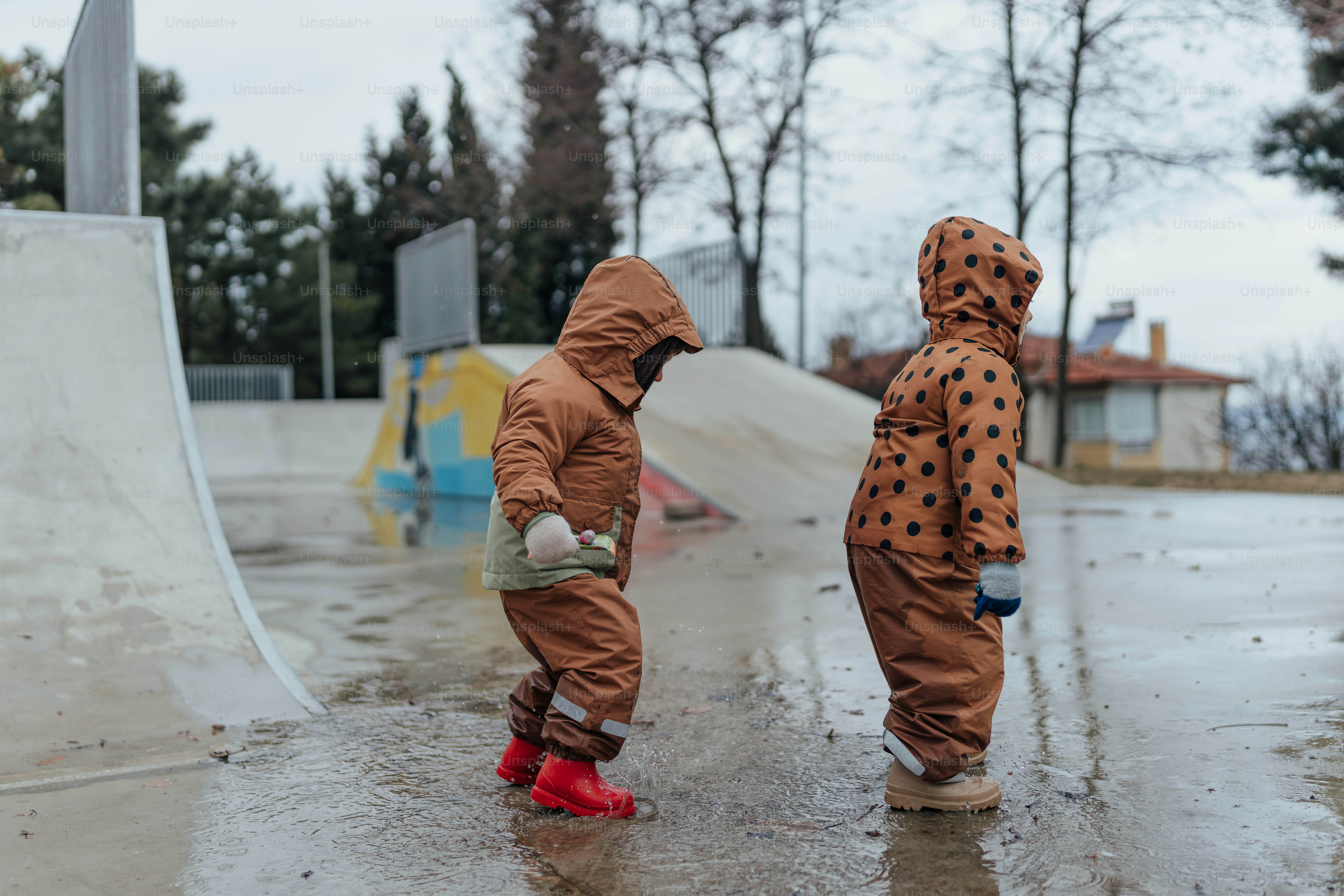 Un par de niños que están parados bajo la lluvia