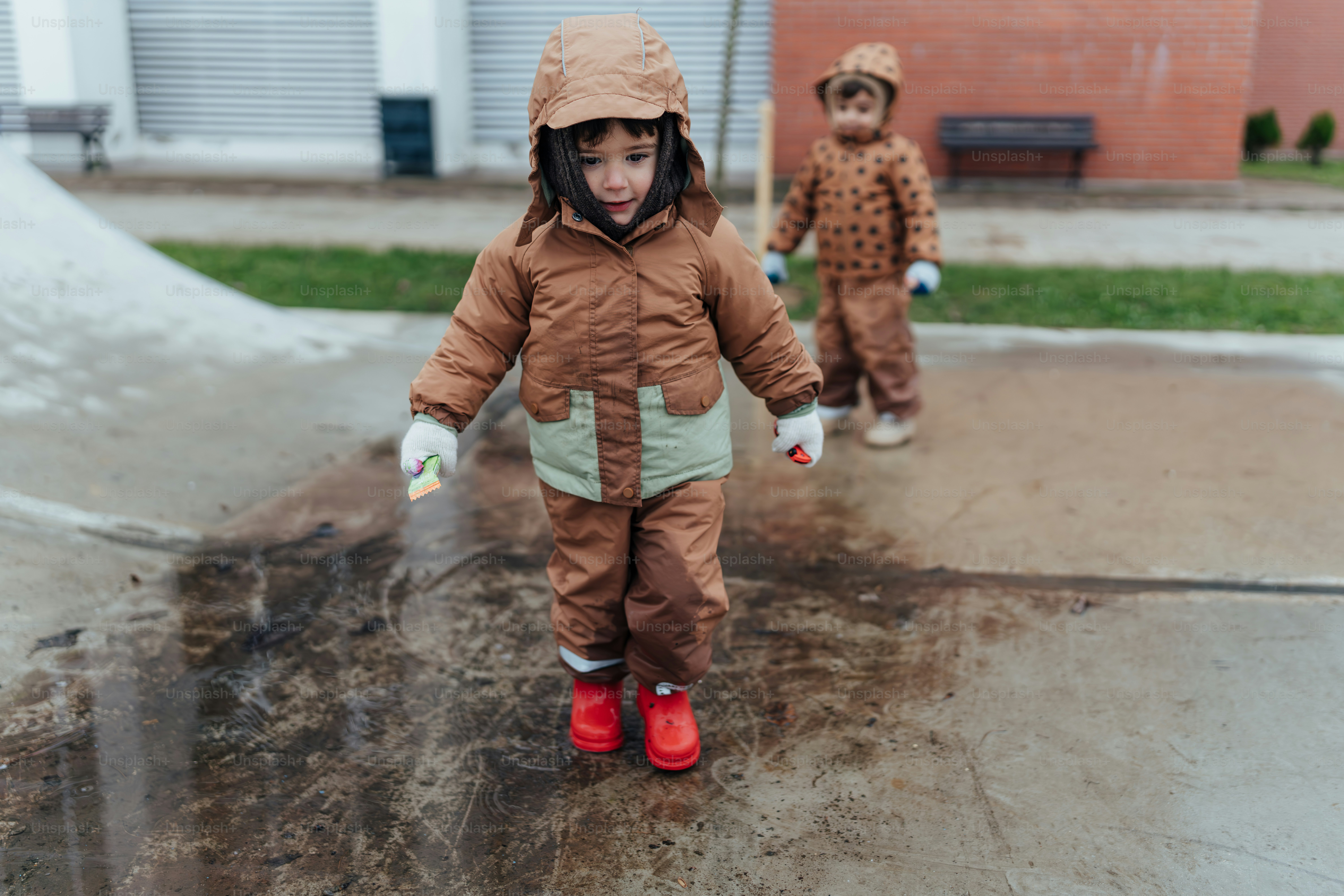 Una niña con un traje de nieve marrón y un niño pequeño con una nieve marrón