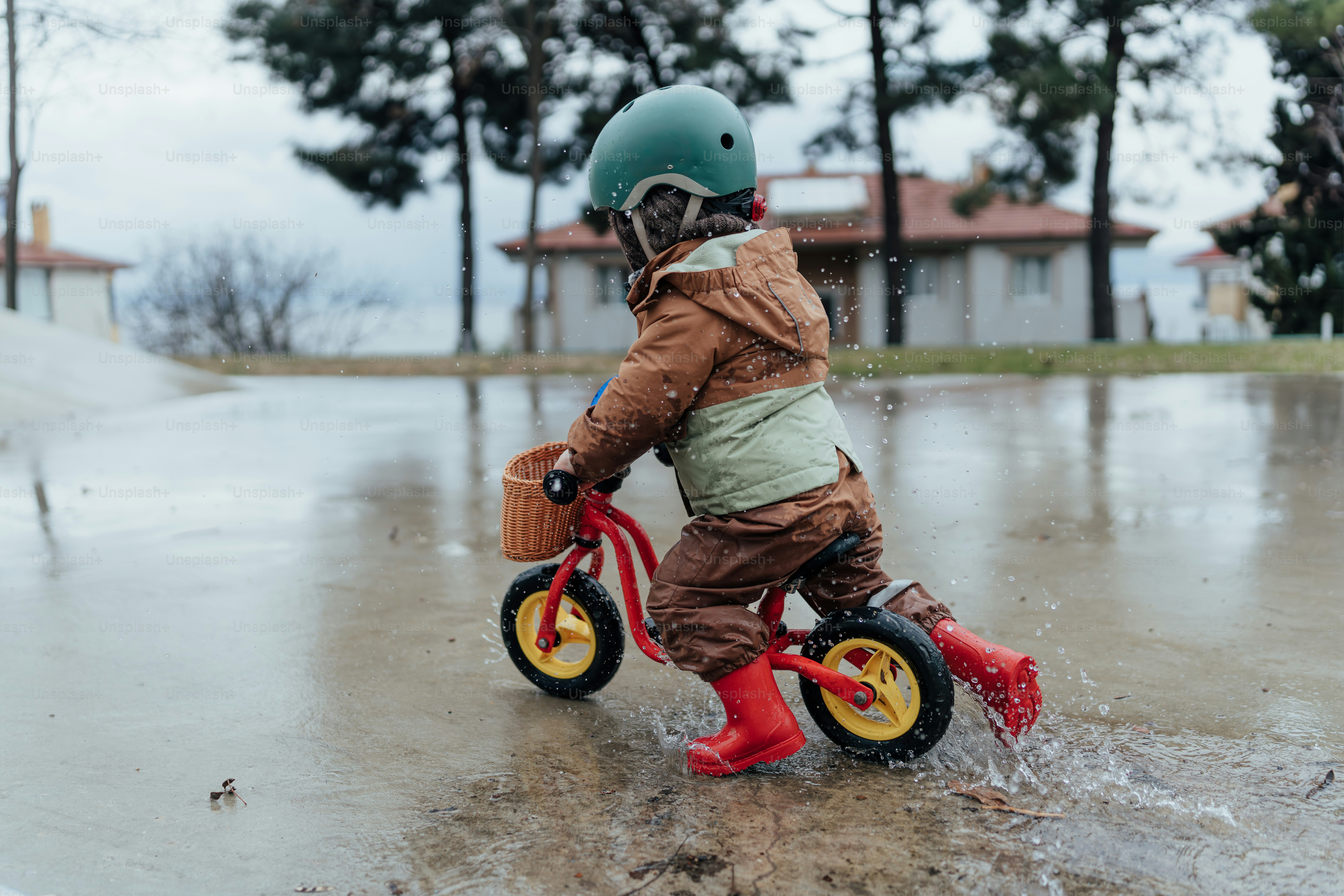 A little boy riding a bike through a puddle of water