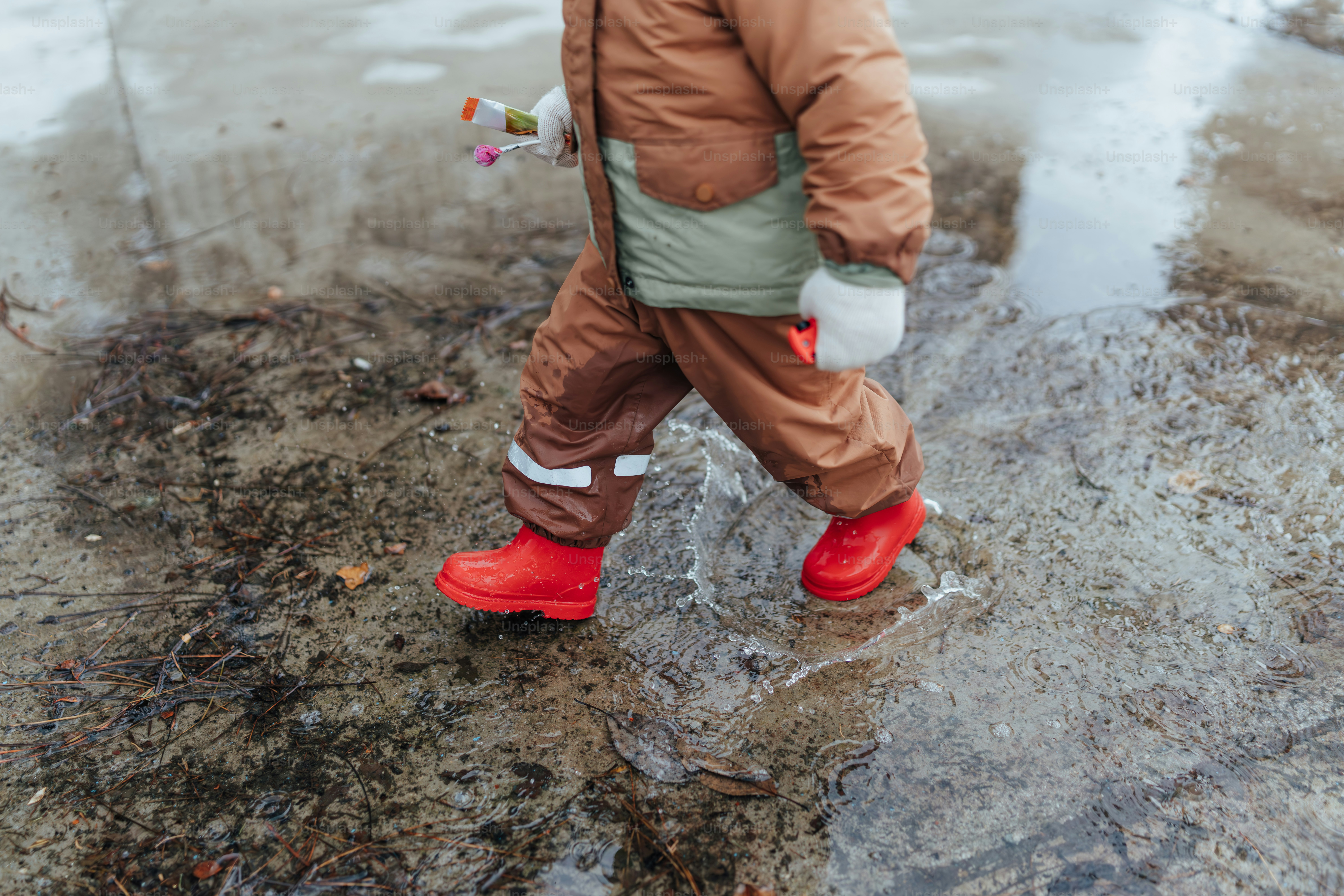 Un niño pequeño caminando a través de un charco de agua