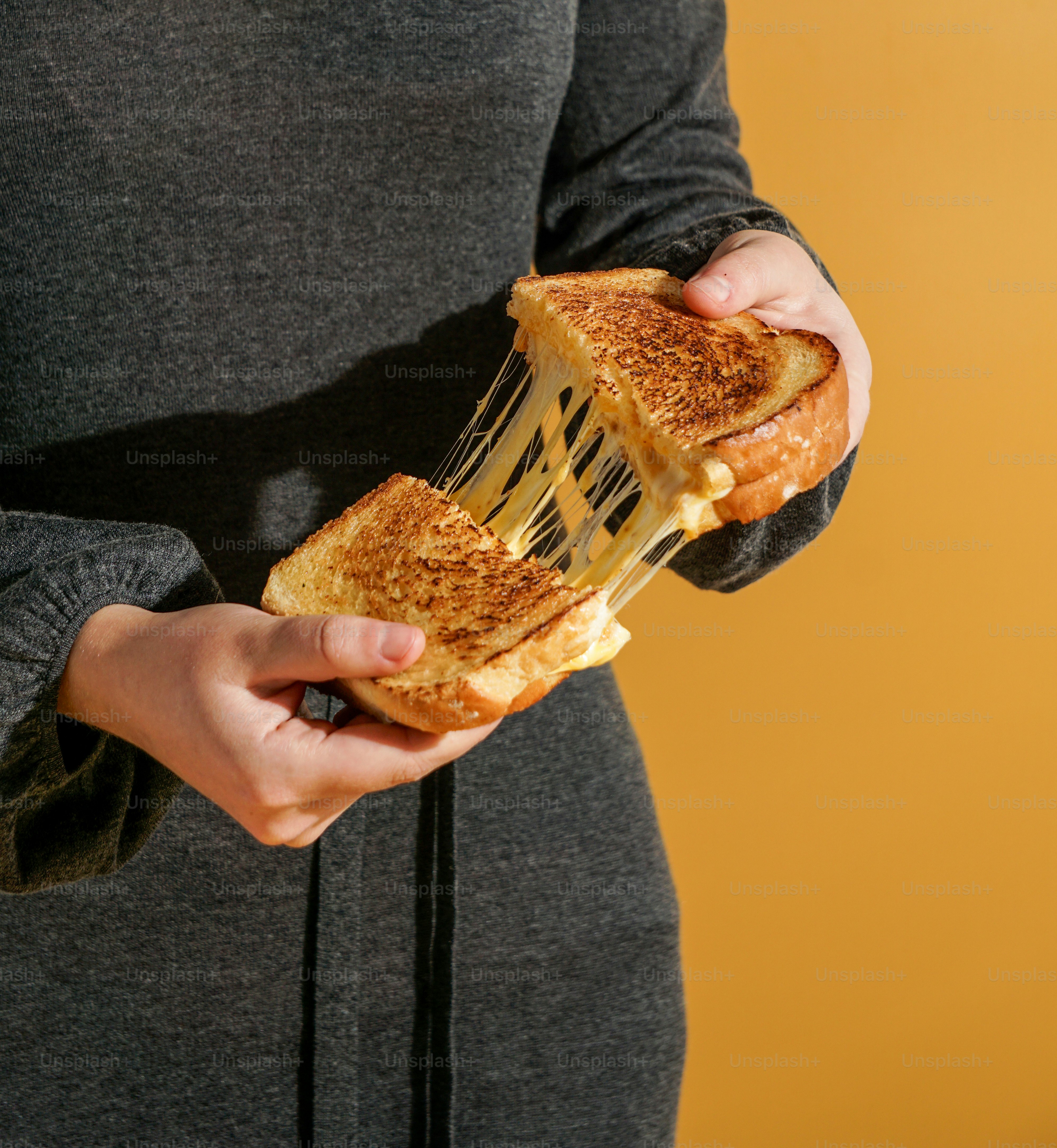 Una persona sosteniendo un sándwich en sus manos