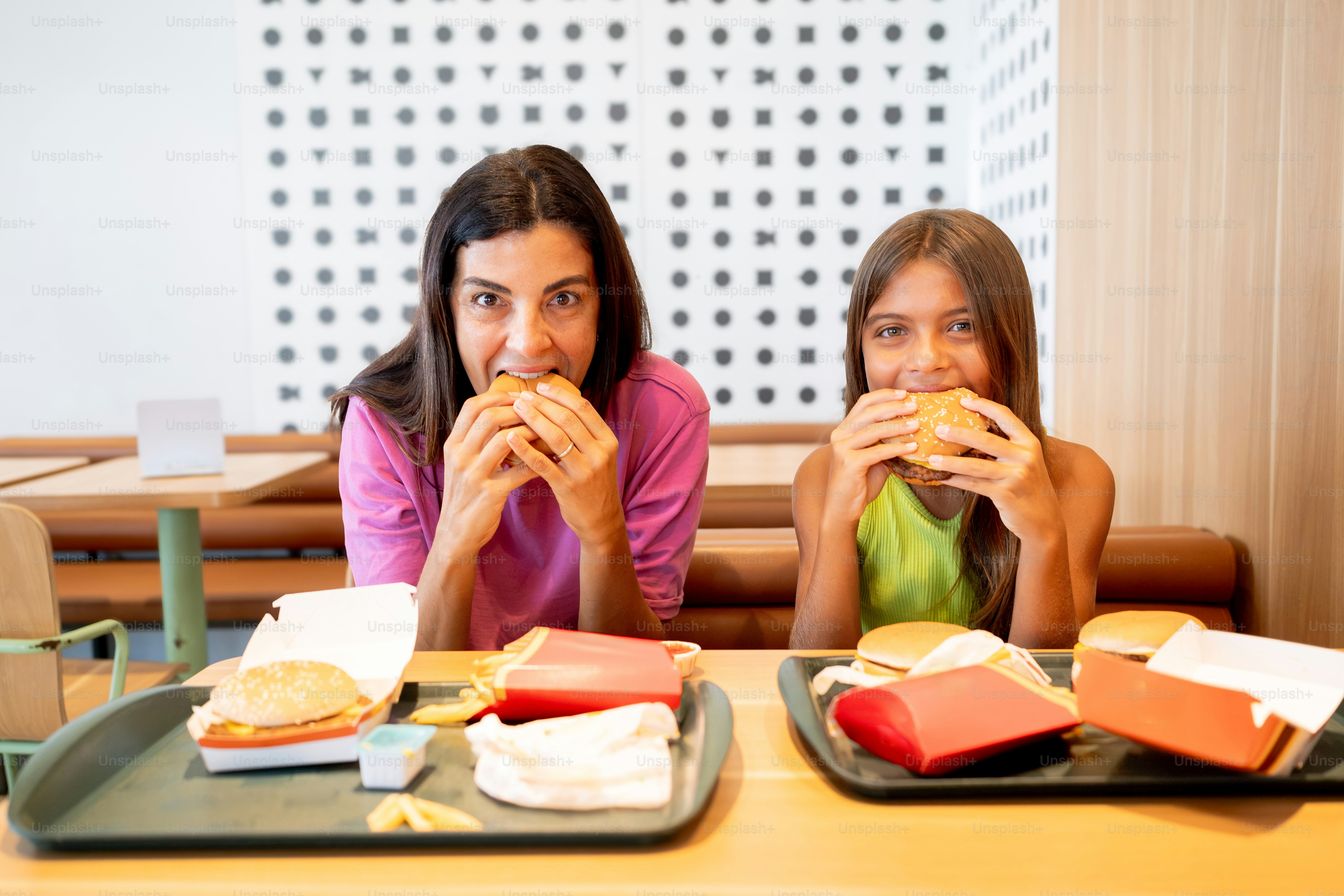 A couple of women sitting at a table eating food