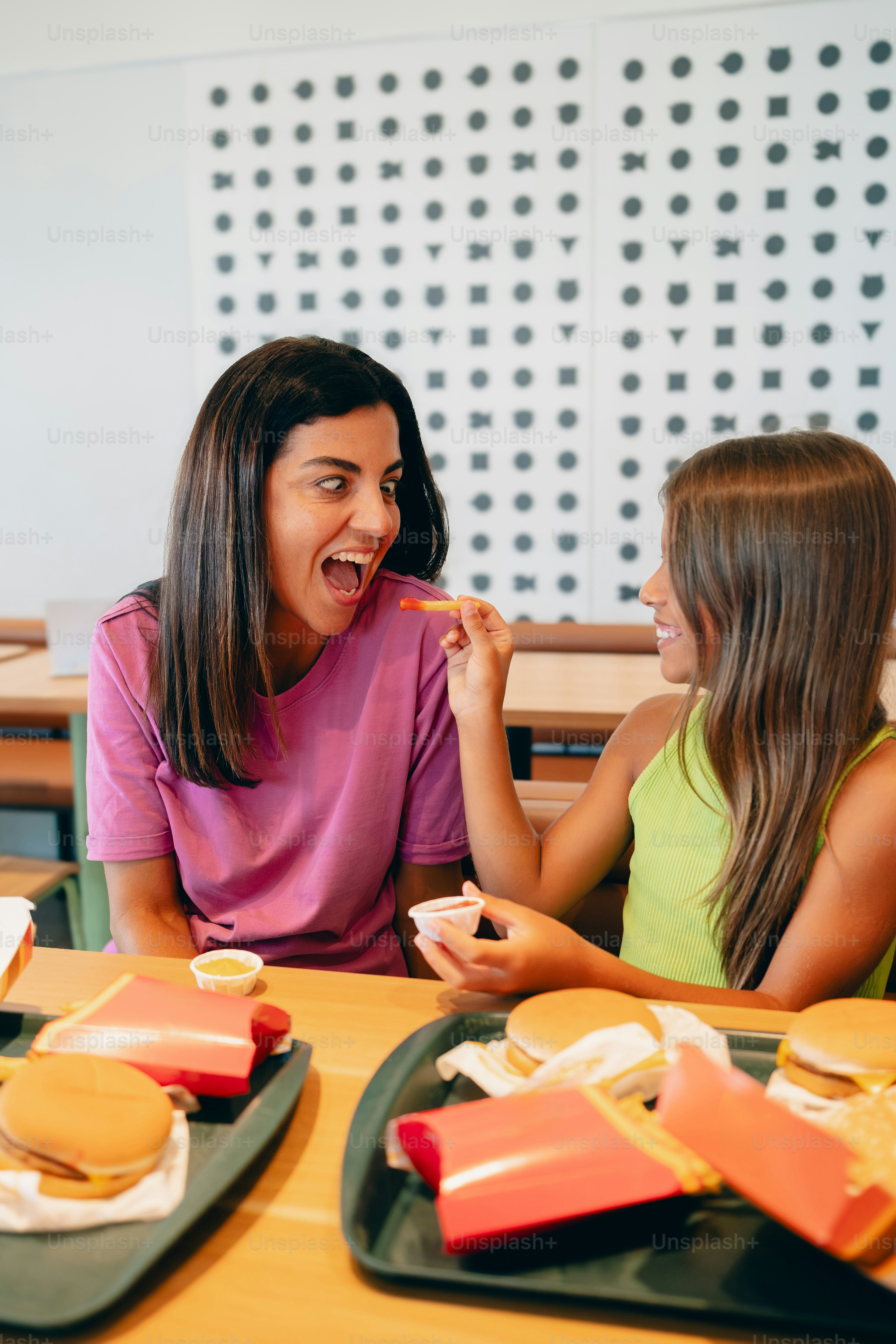 Two girls sitting at a table eating food