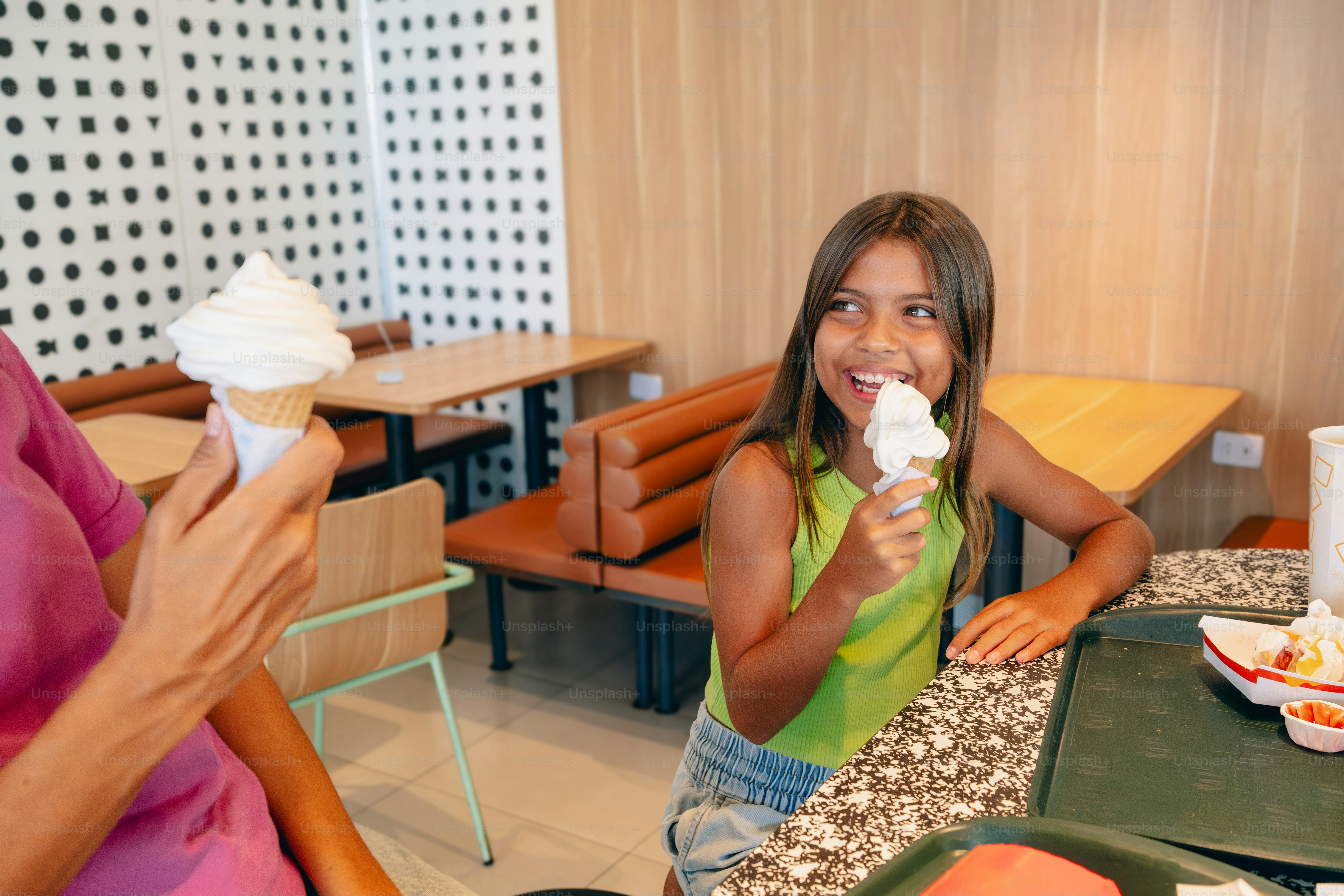 A woman and a girl sitting at a table eating food