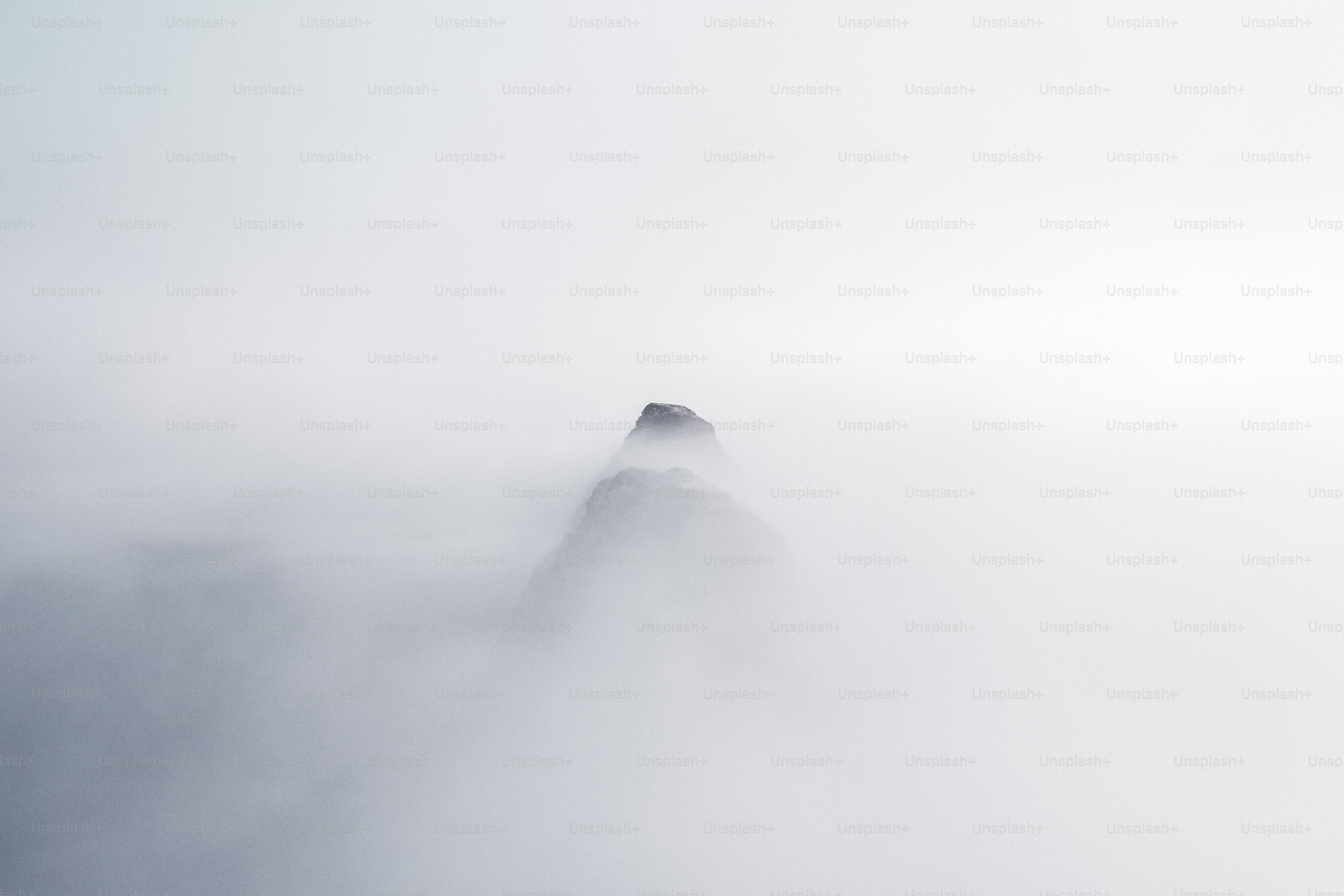A mountain covered in fog and low lying clouds