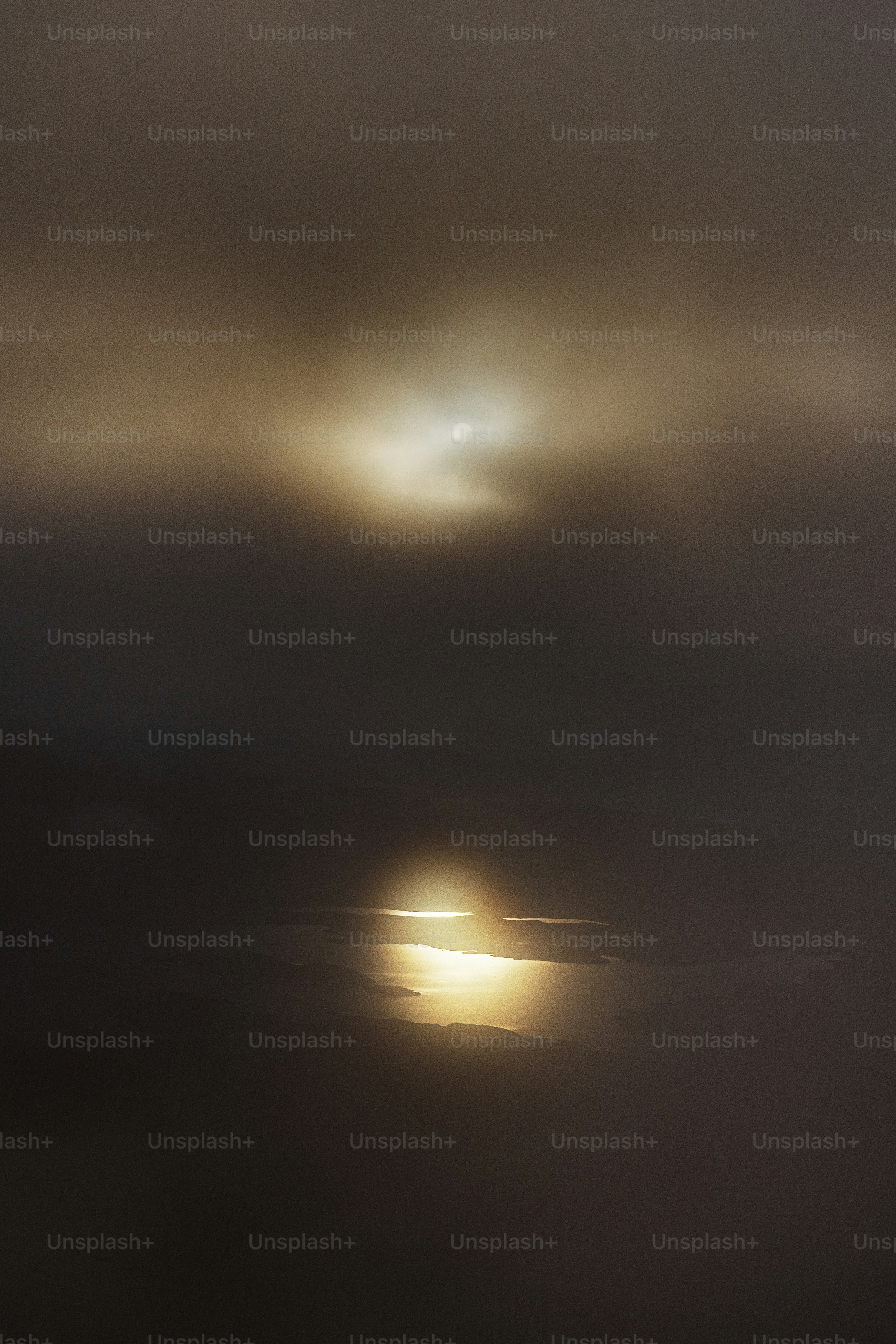 The sun is shining through the clouds over the ocean