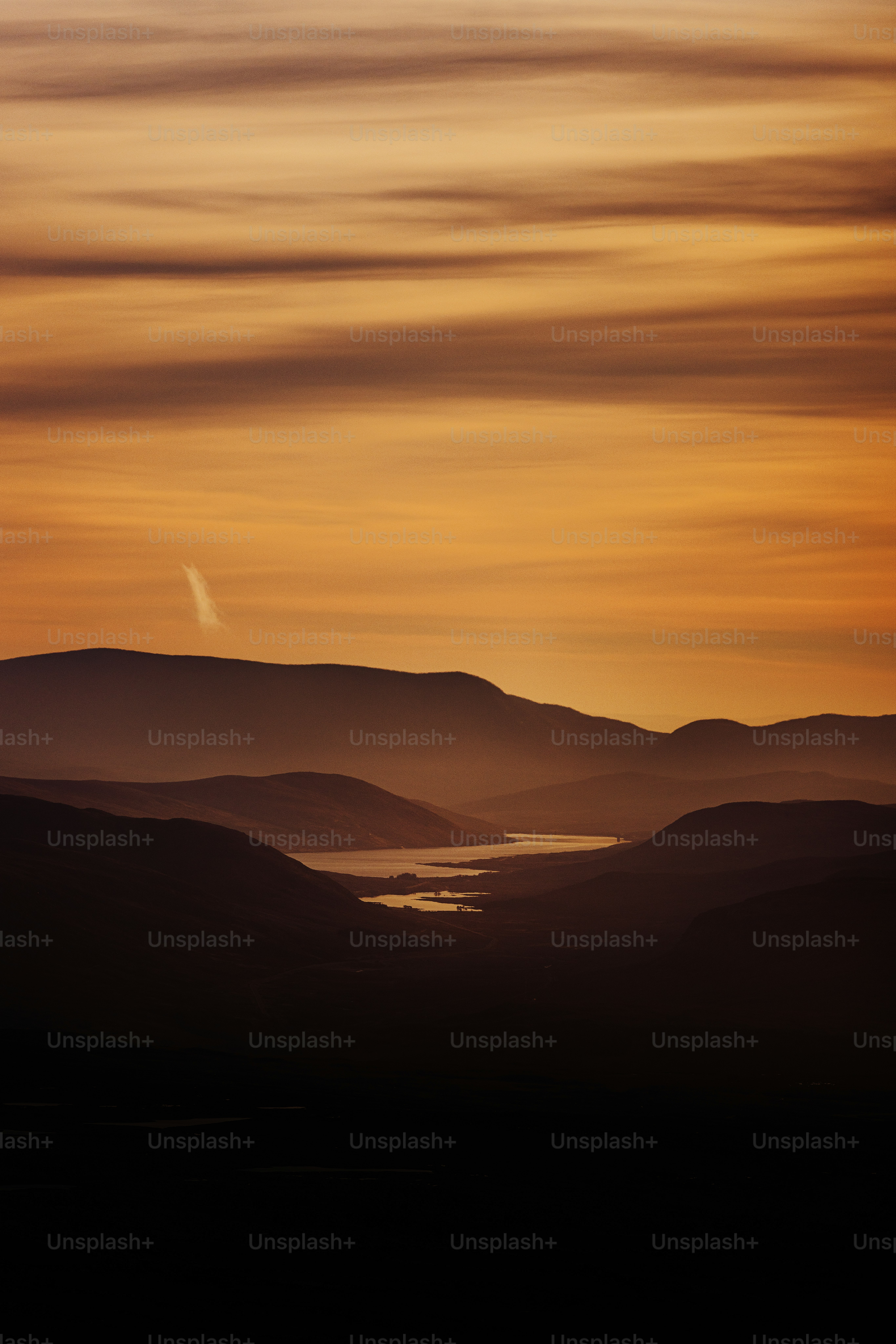 A sunset view of a lake and mountains