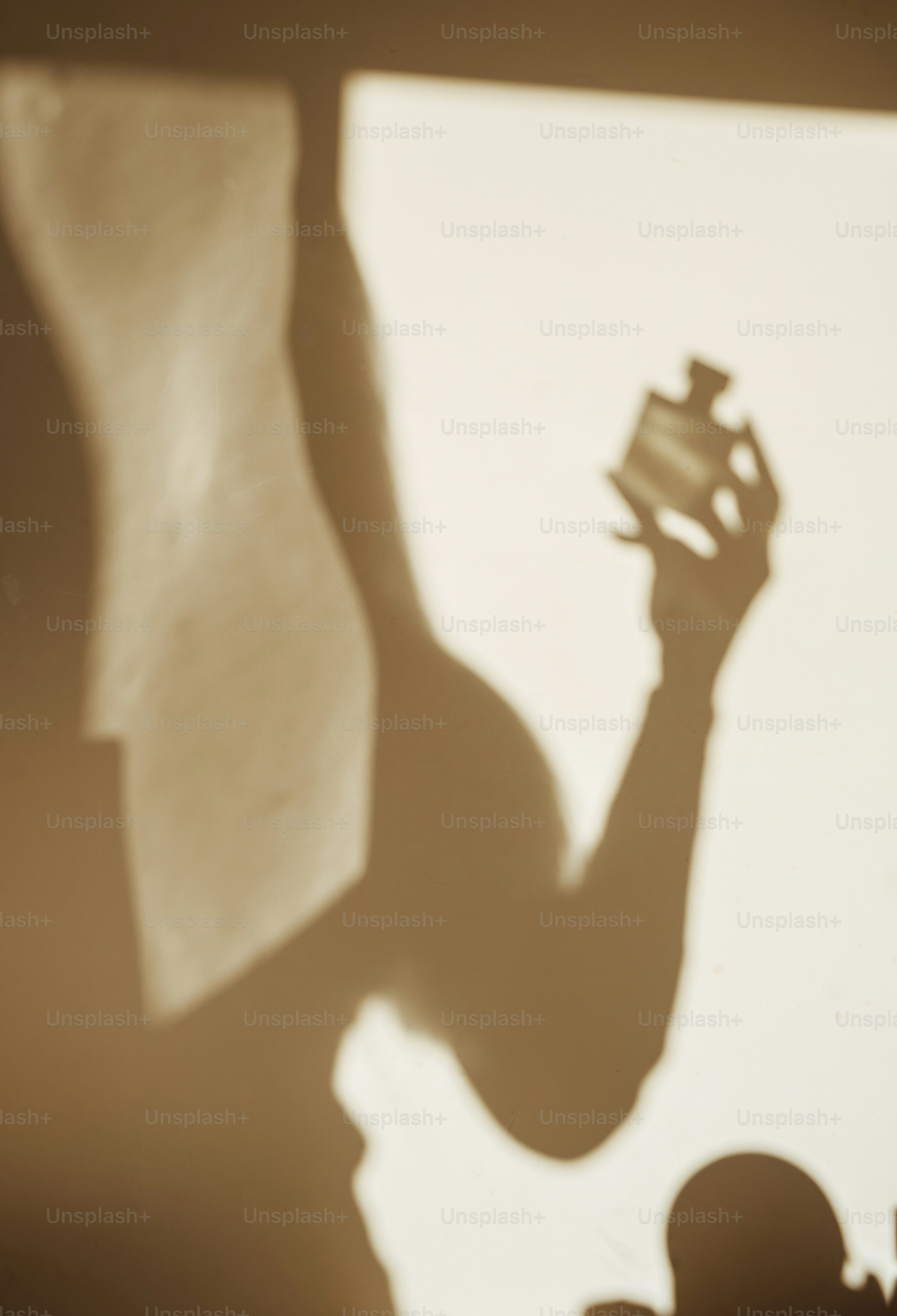 A shadow of a person holding a piece of paper