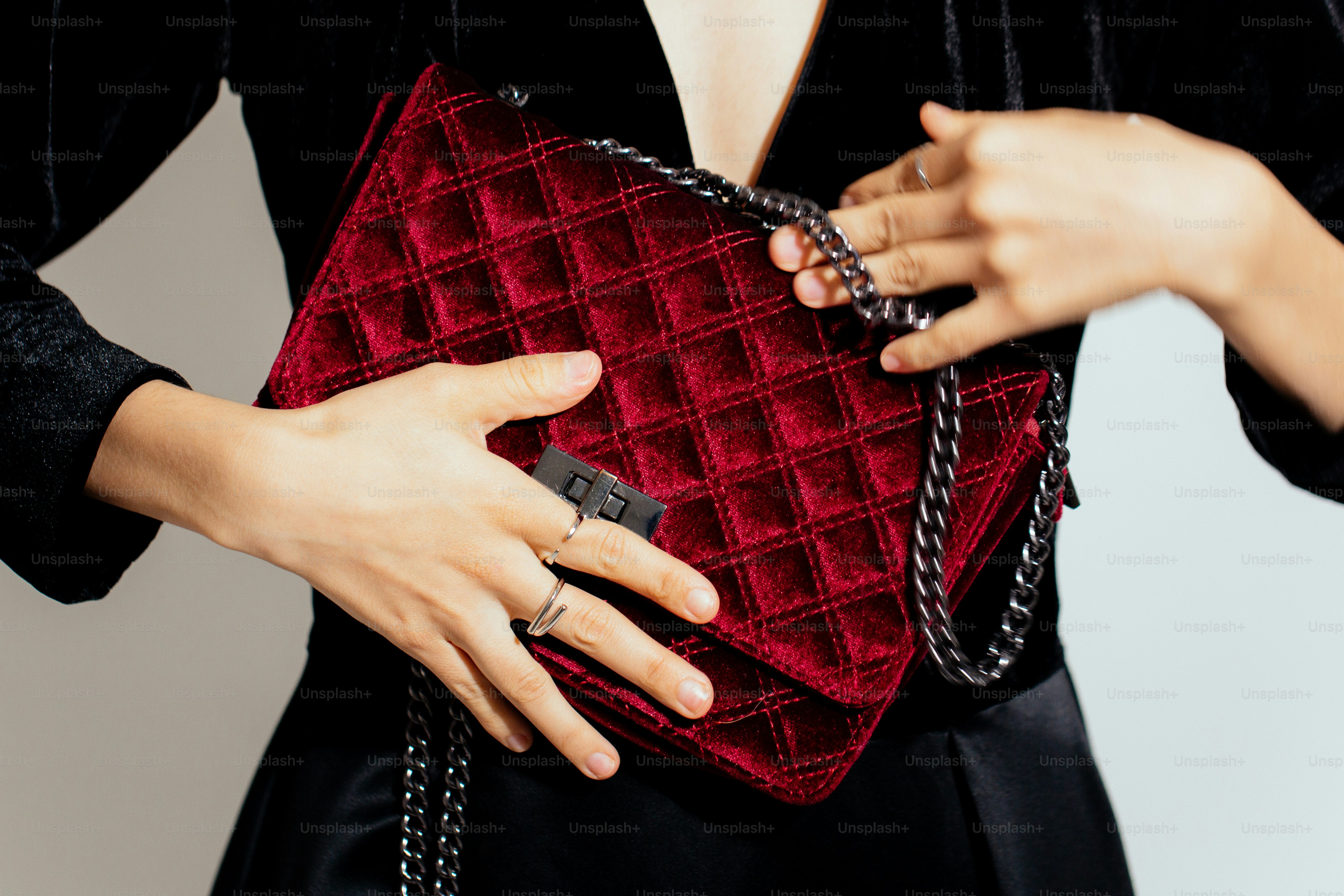 A woman holding a red quilted purse
