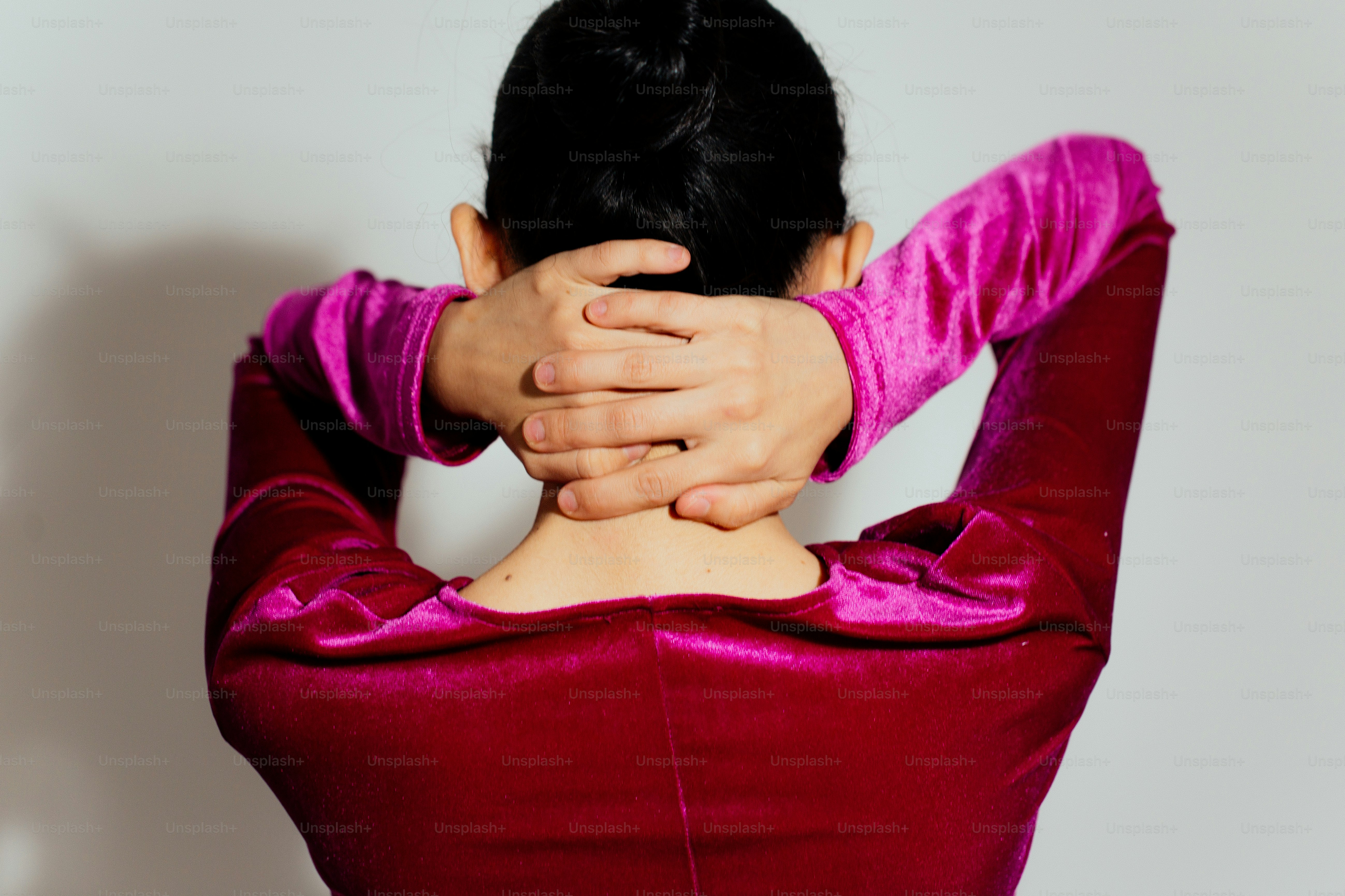 A woman in a red dress covering her face with her hands