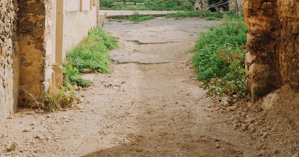A stone archway with a dirt path leading into the distance photo ...