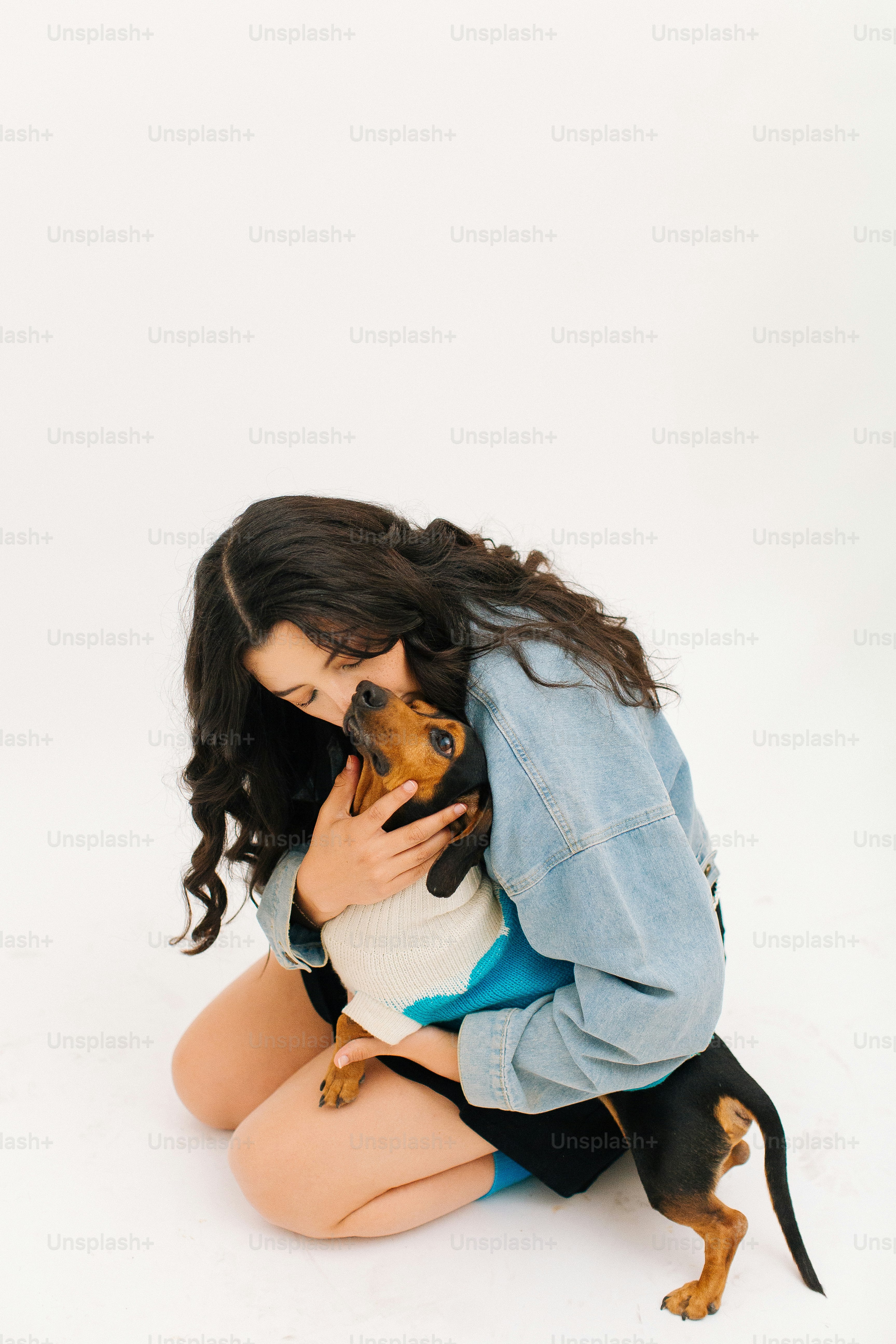 Une femme agenouillée tenant un petit chien