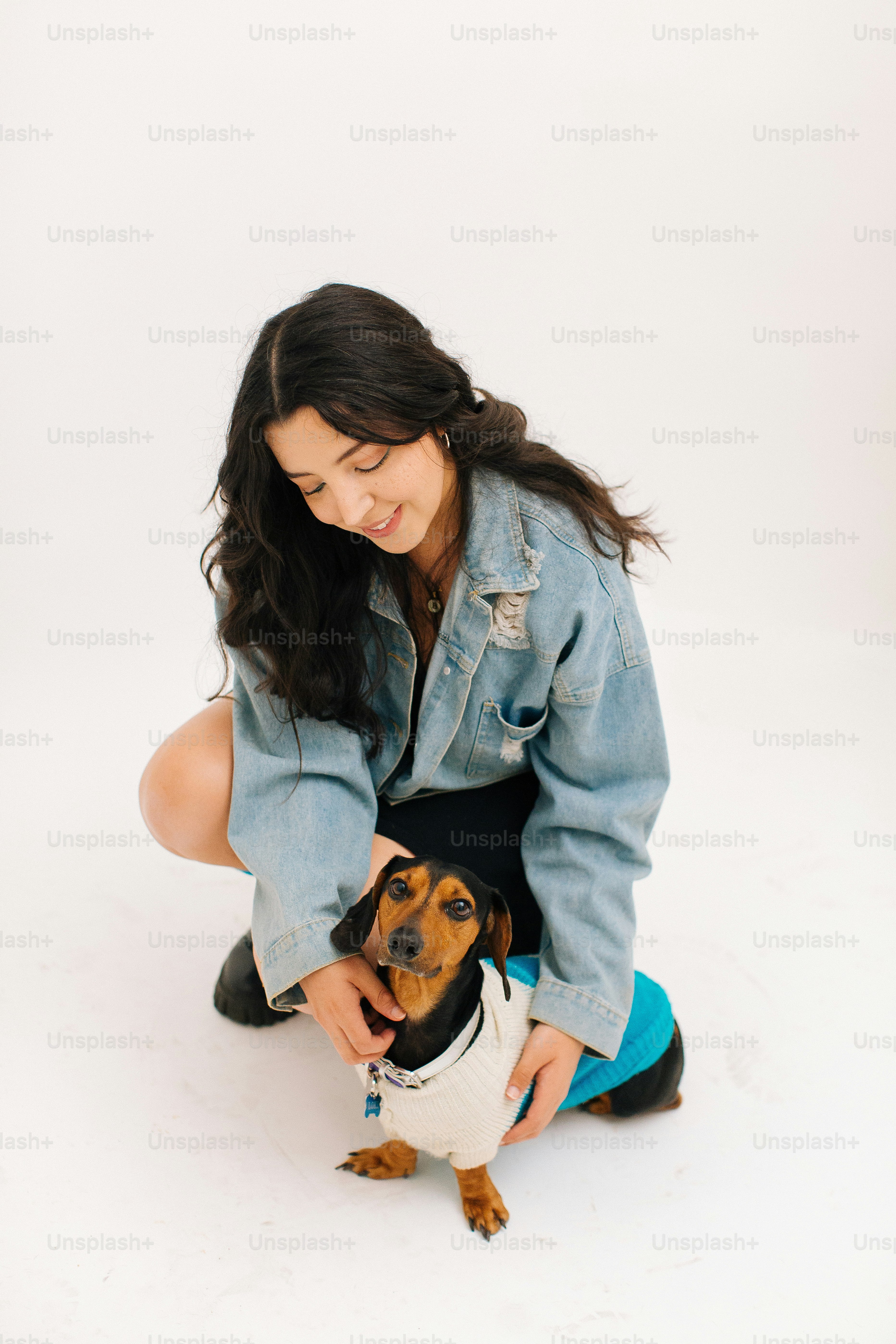 Une femme agenouillée caressant un petit chien