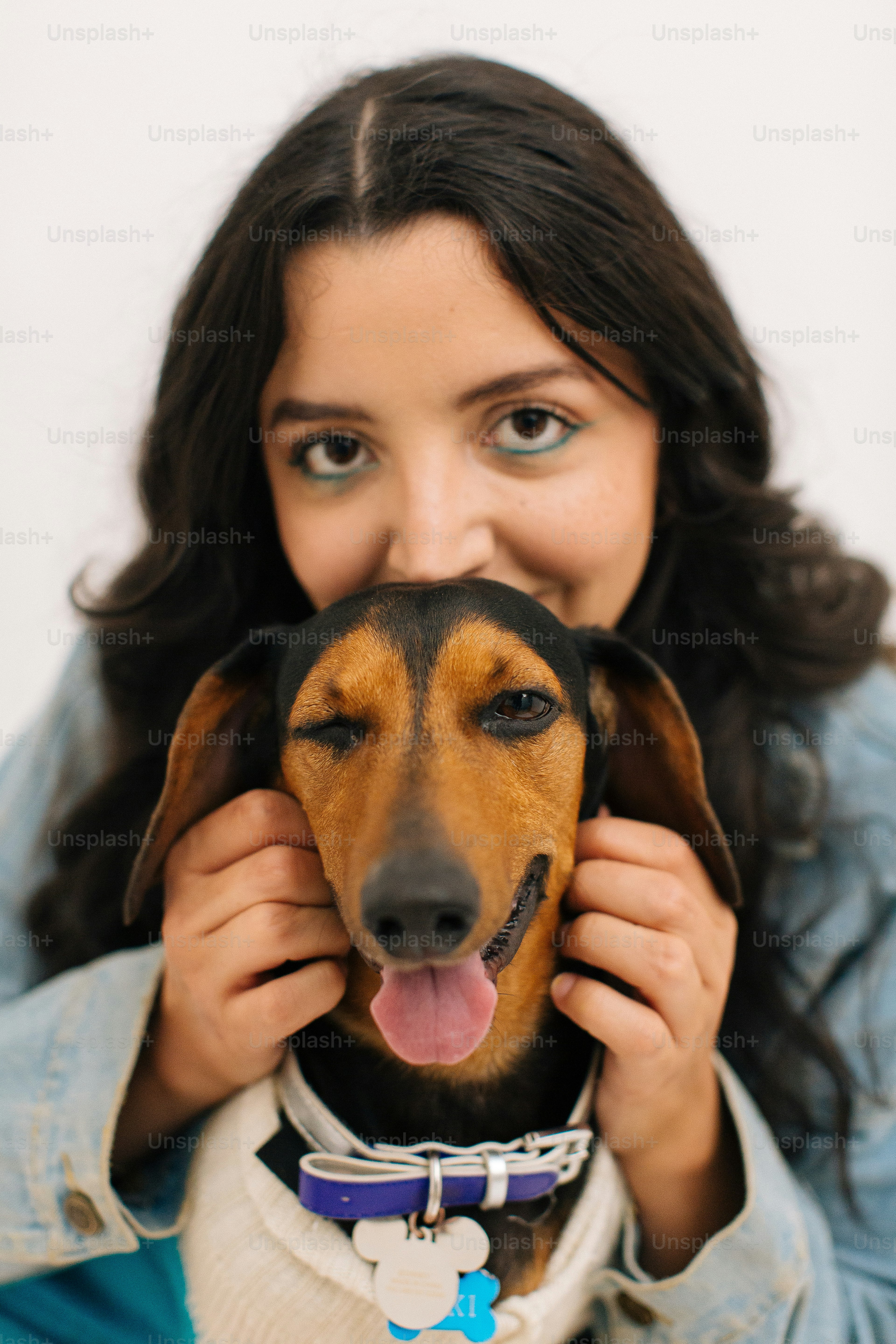 Une femme tenant un chien contre son visage