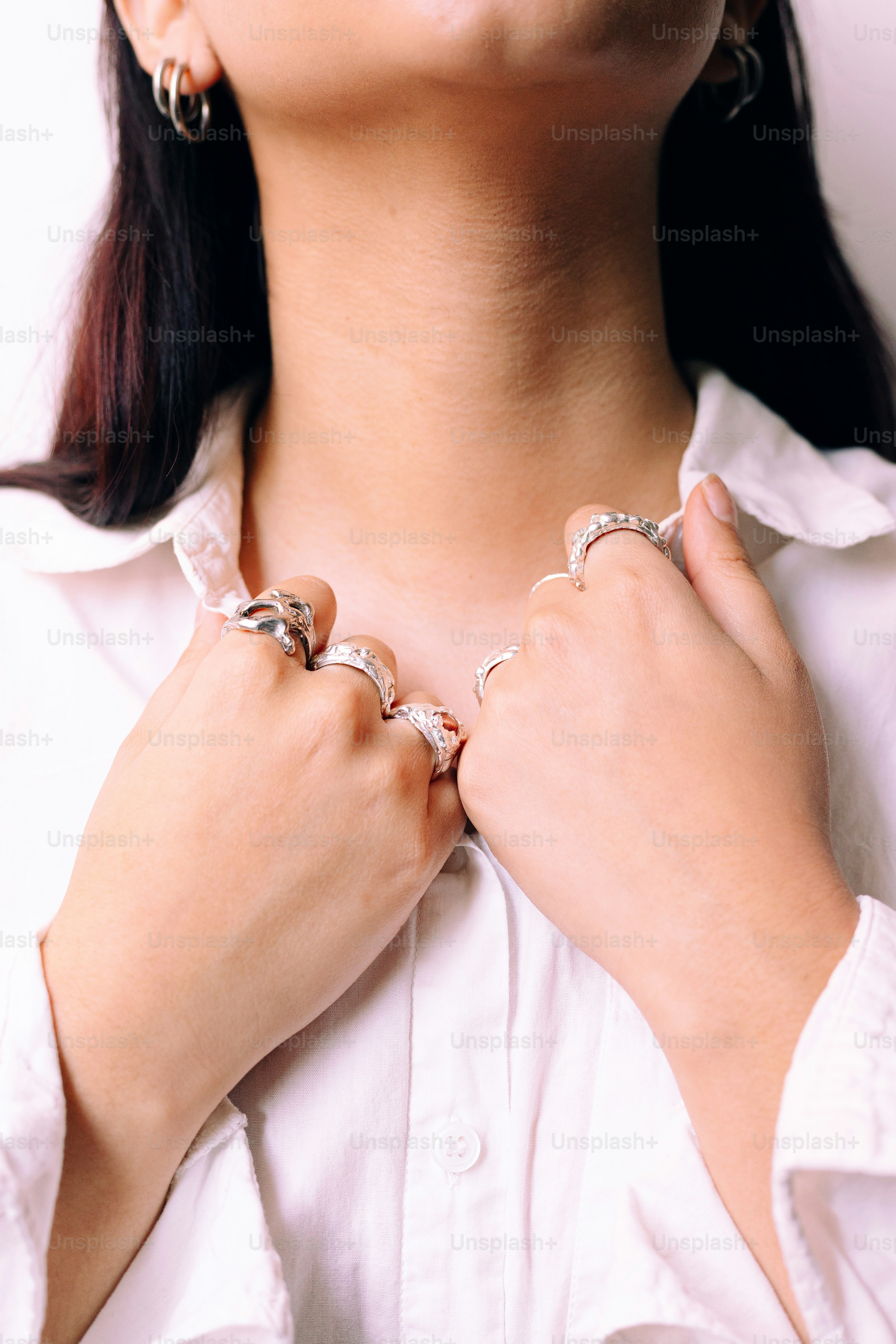 A woman wearing a white shirt and silver jewelry