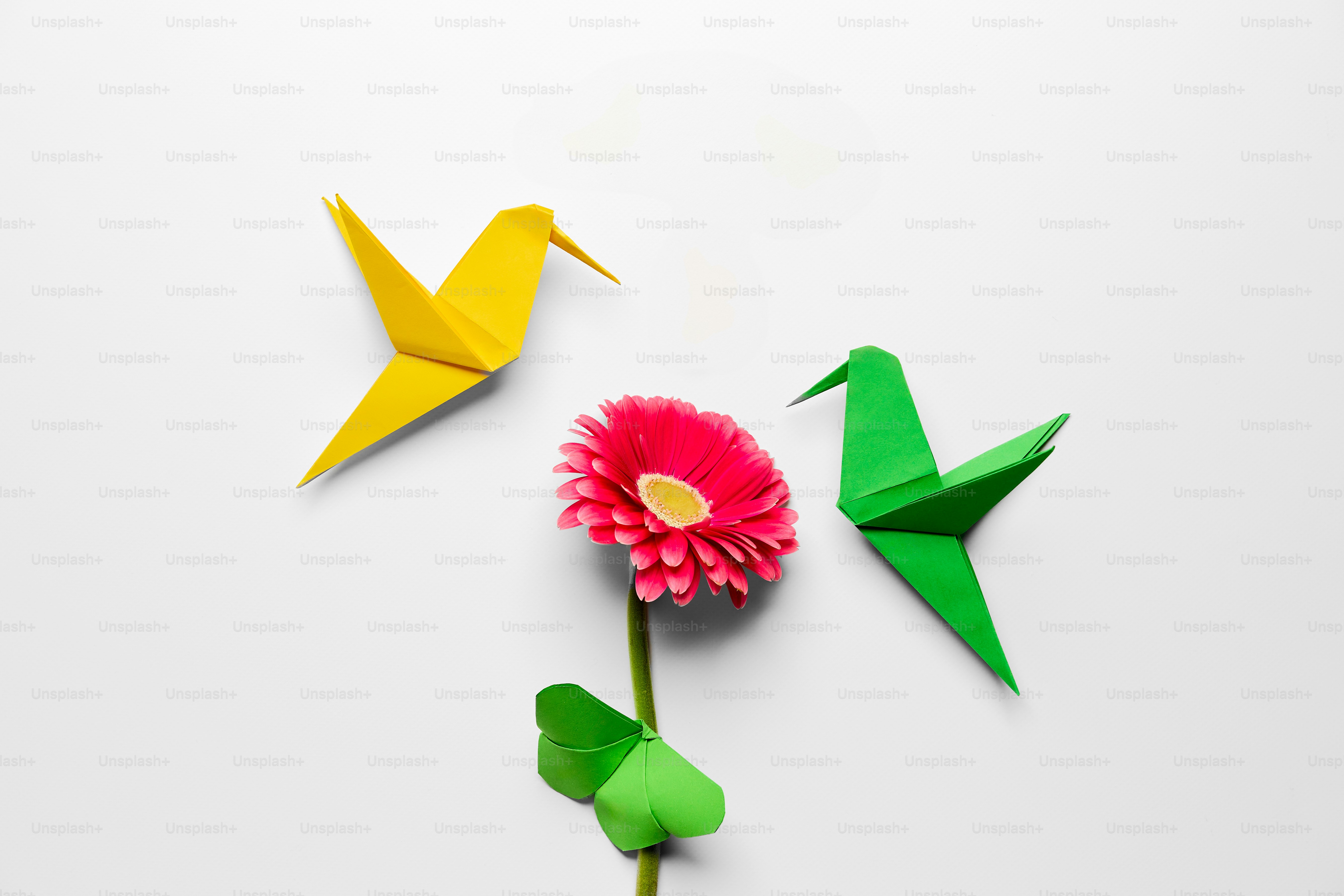 Three origami birds and a flower on a white background