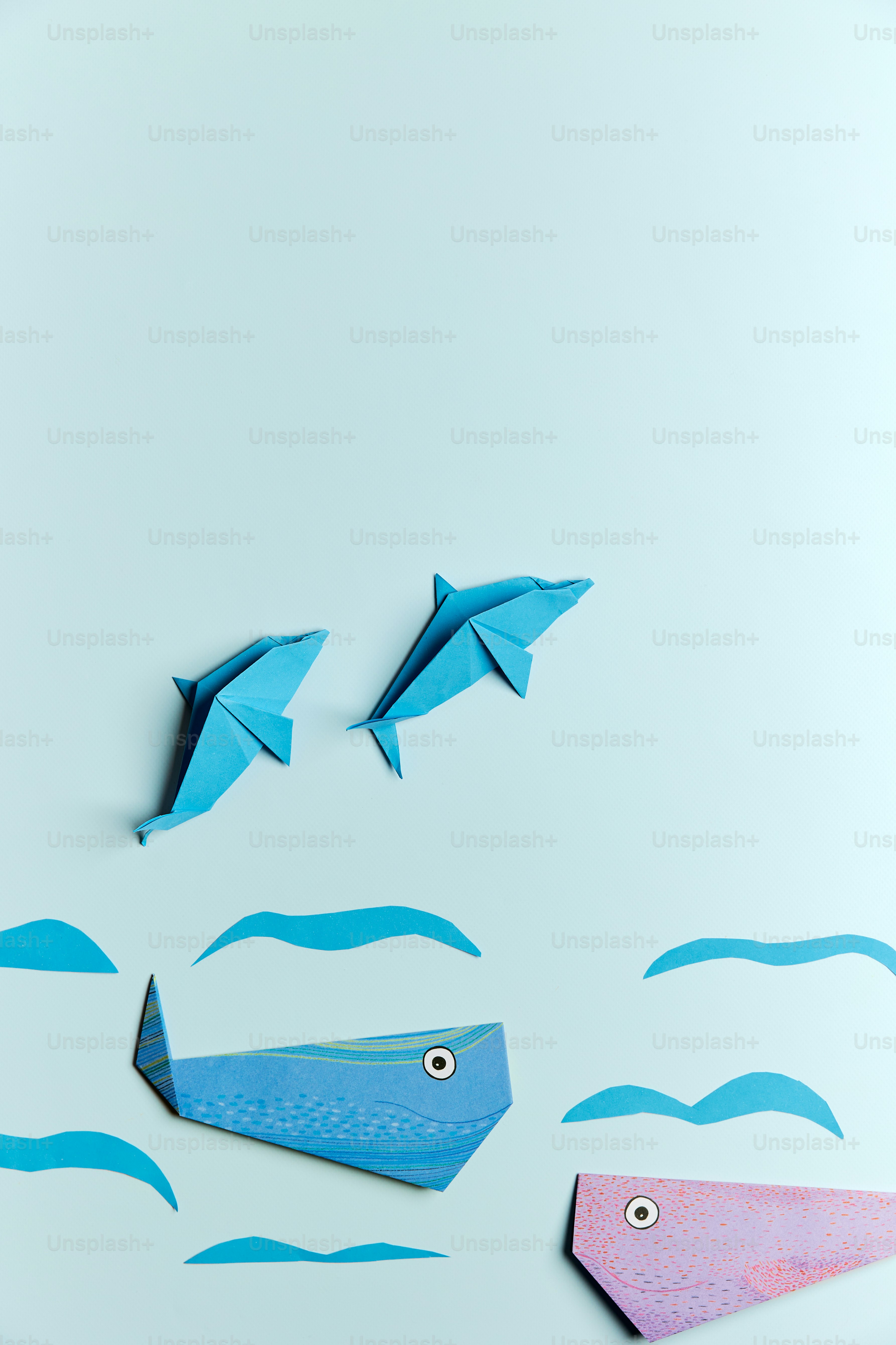 A group of paper fish floating on top of a body of water photo ...