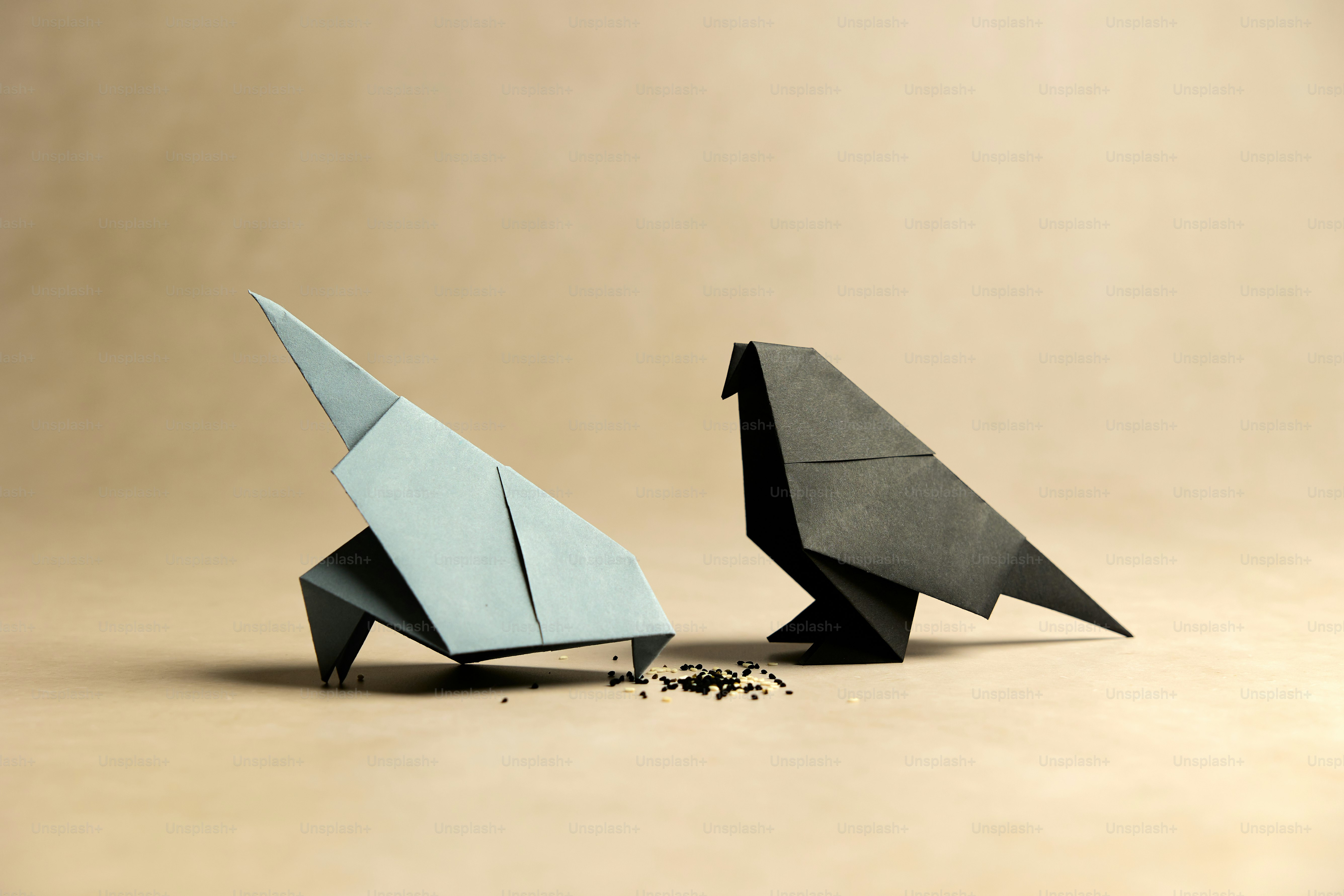 A couple of origami birds sitting next to each other