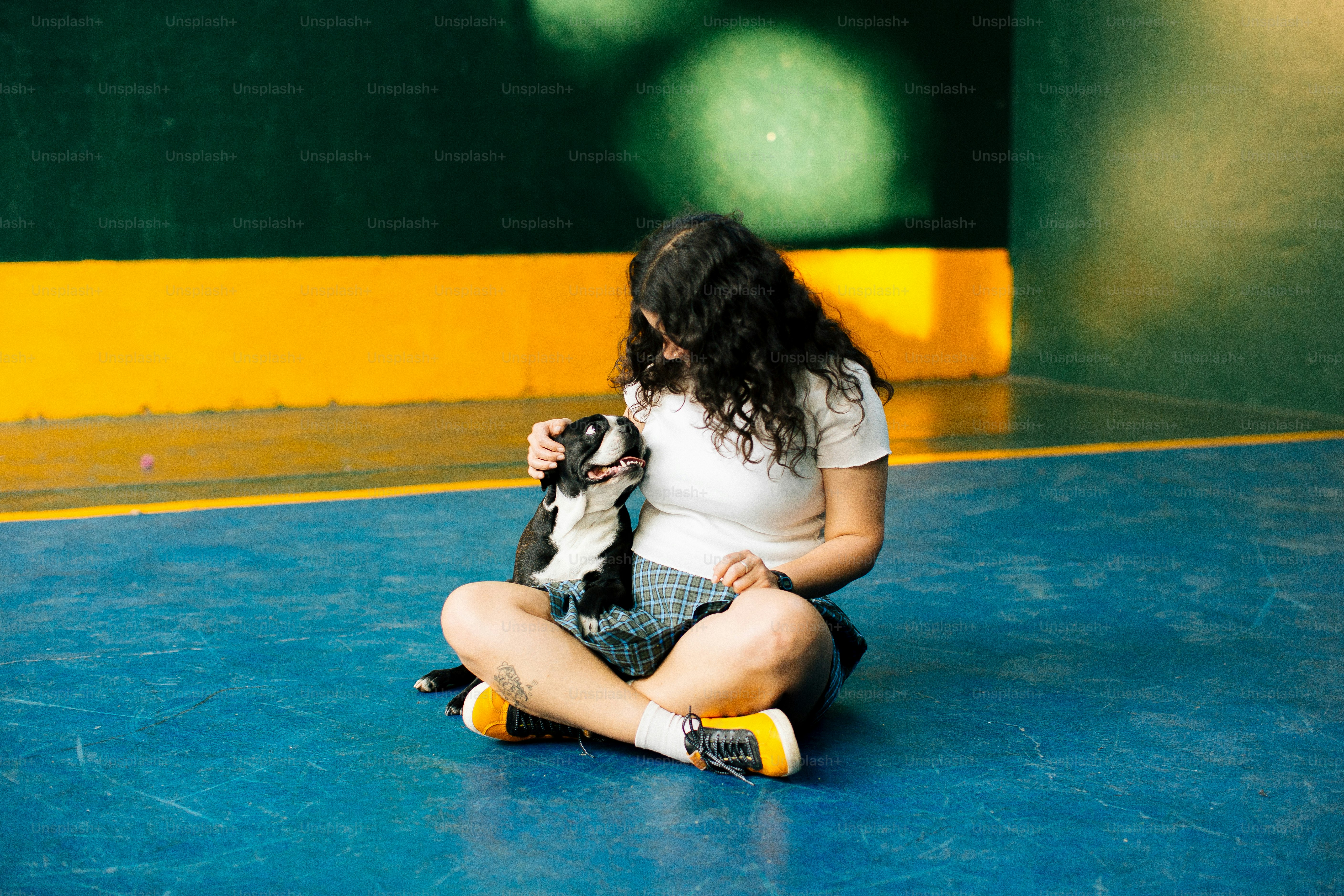 A woman sitting on the floor holding a dog