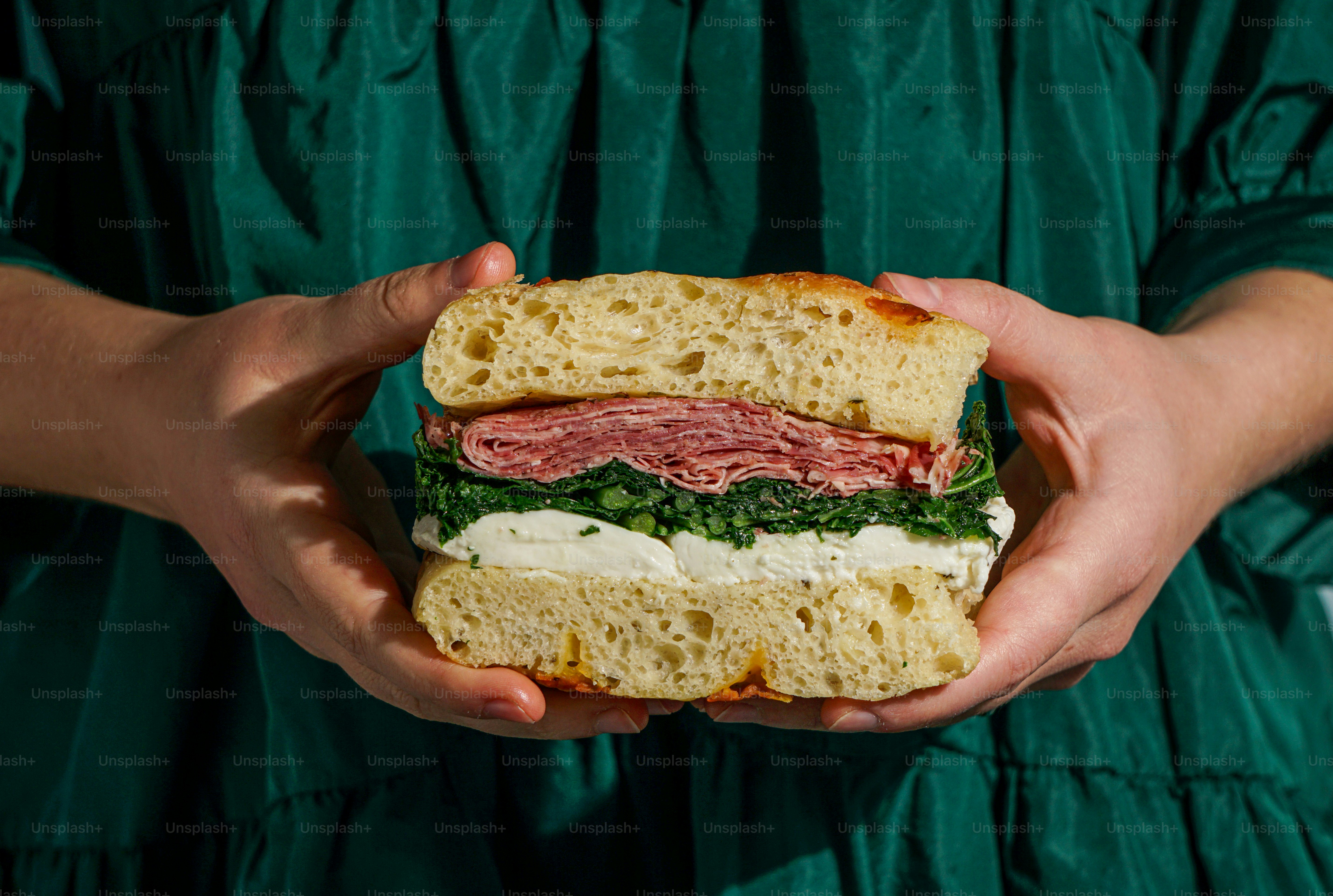 A person holding a sandwich in their hands