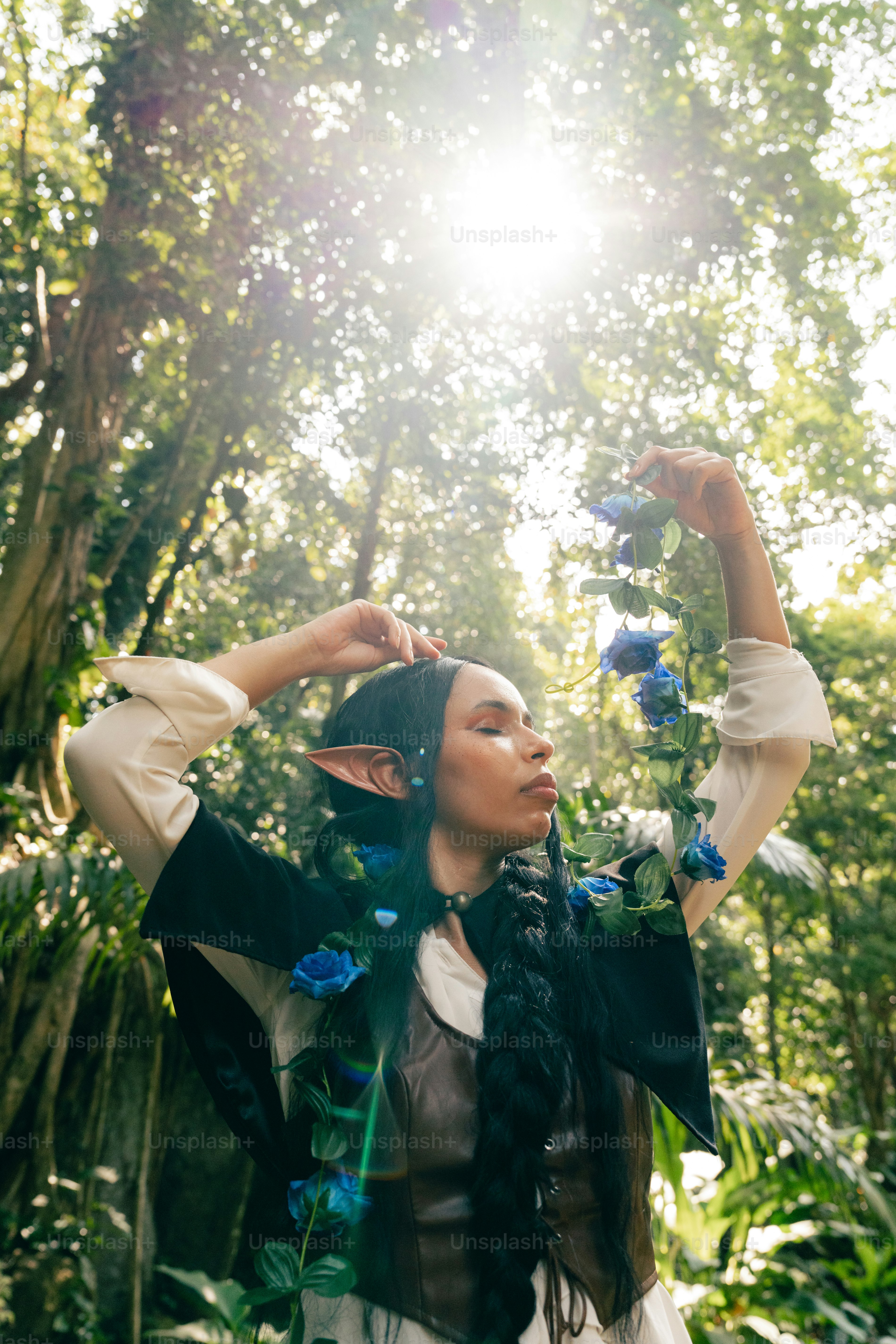 Seorang wanita berdiri di hutan memegang bunga