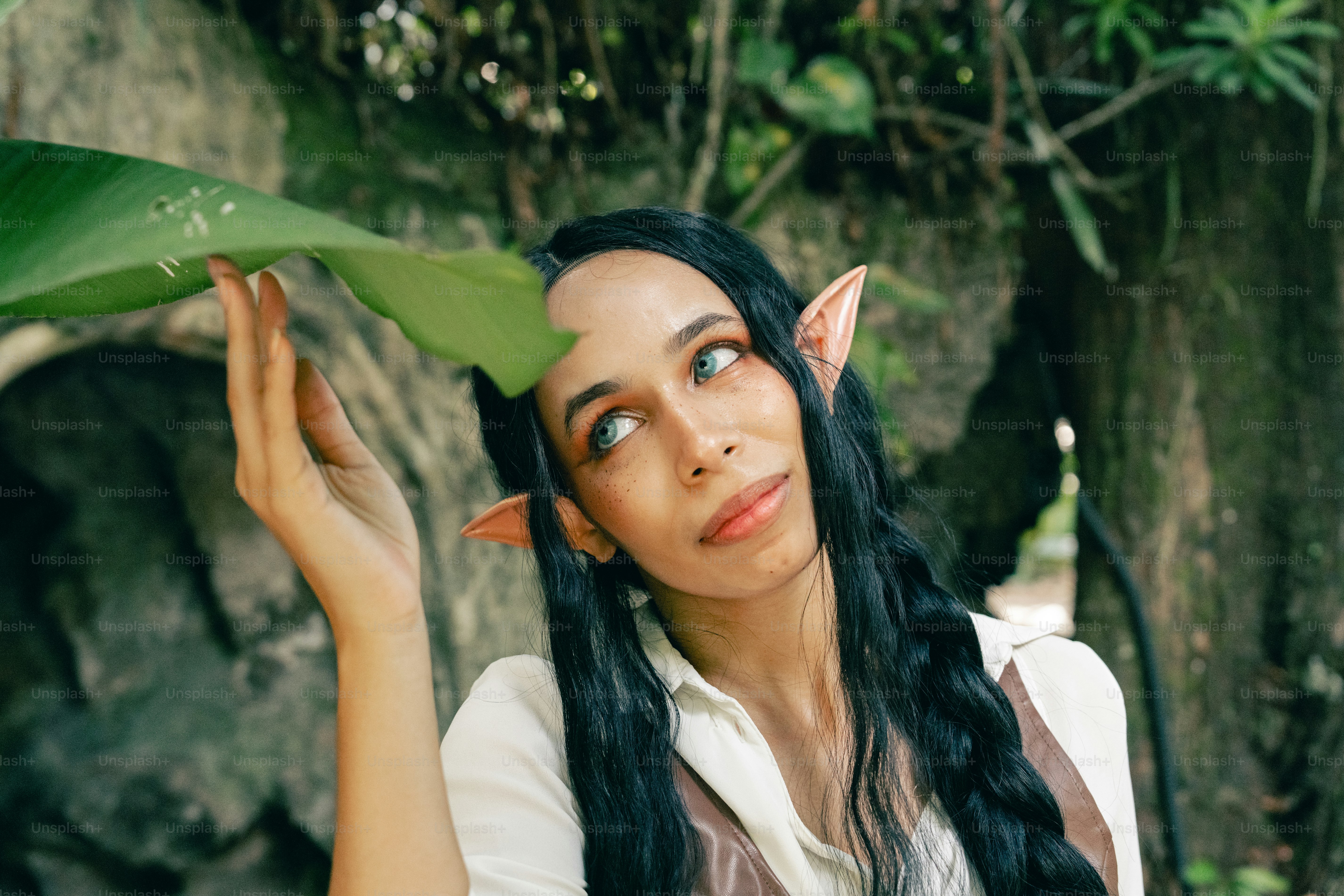 Una mujer con el pelo largo y negro y una hoja verde