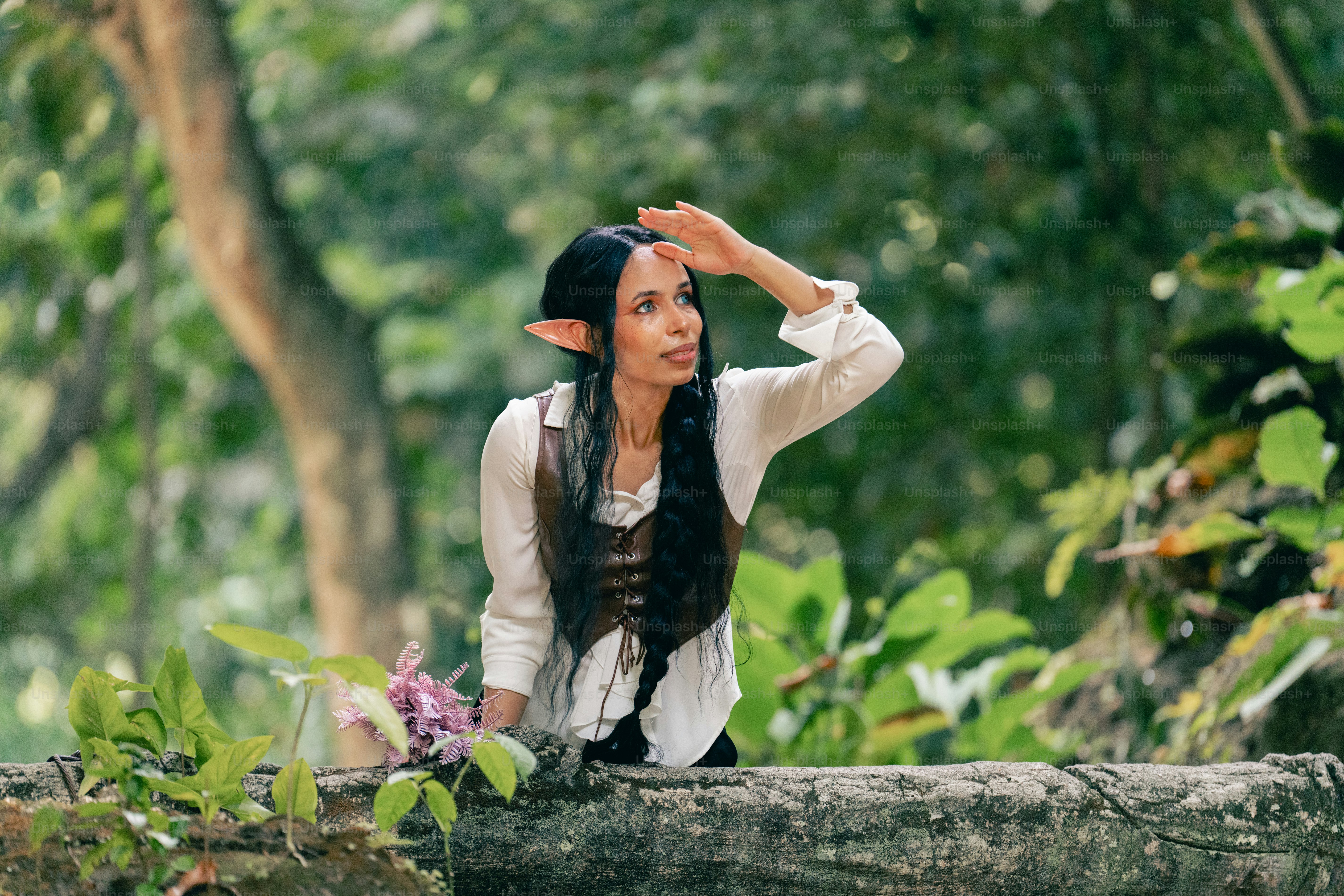 Seorang wanita duduk di atas batang kayu di hutan
