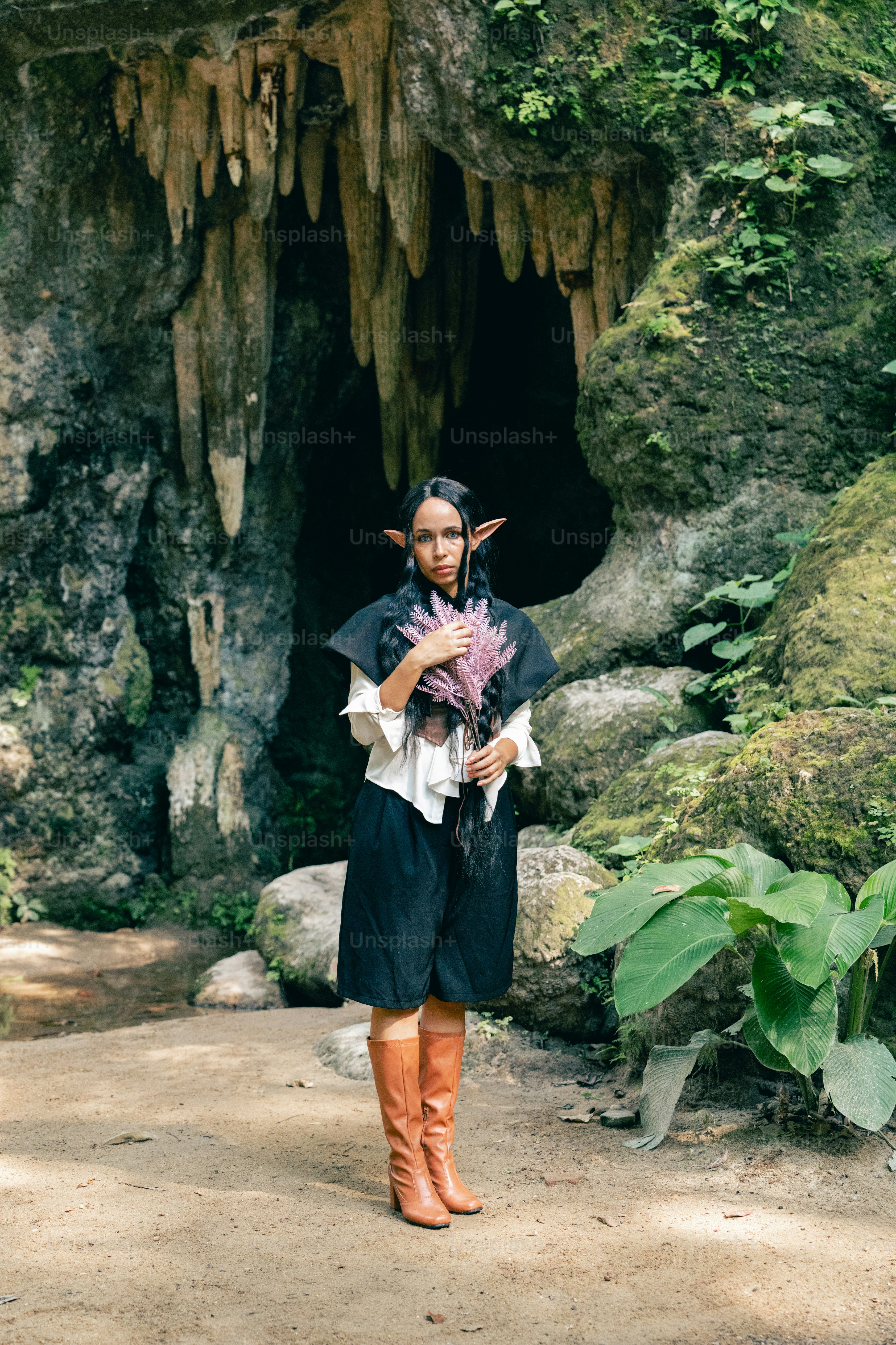 Seorang wanita berdiri di depan gua