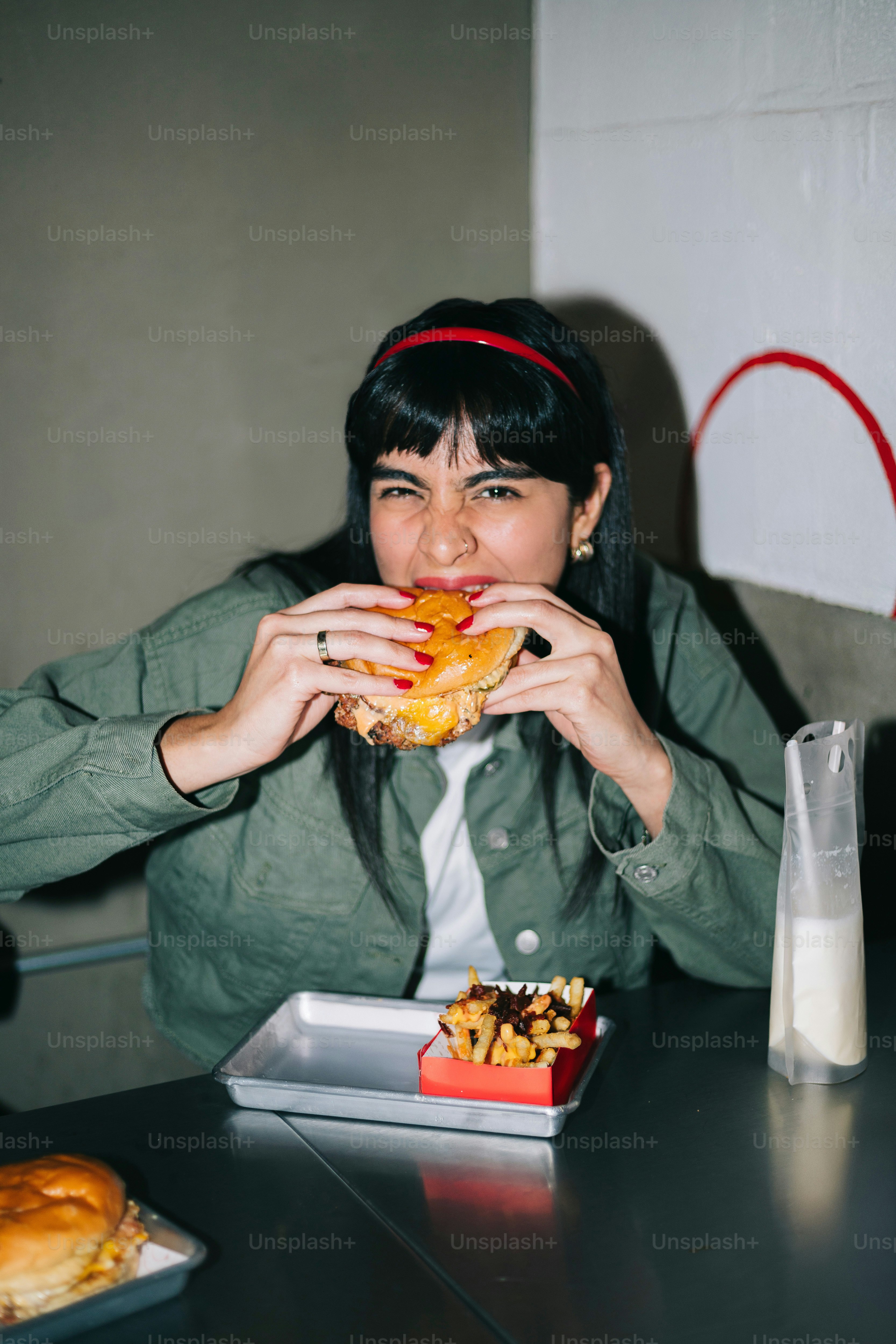 A woman sitting at a table eating a sandwich