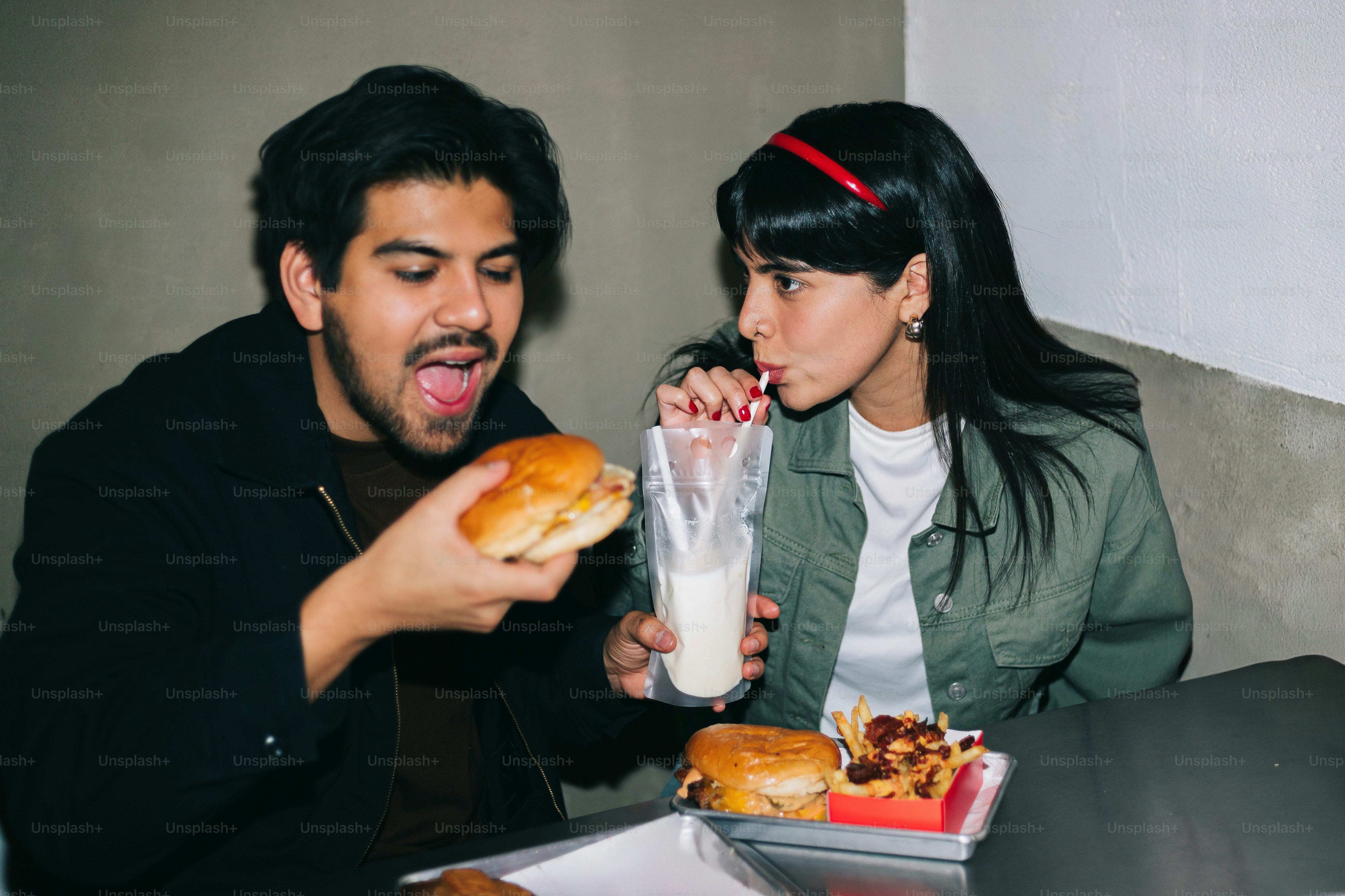 A man and a woman sitting at a table eating food