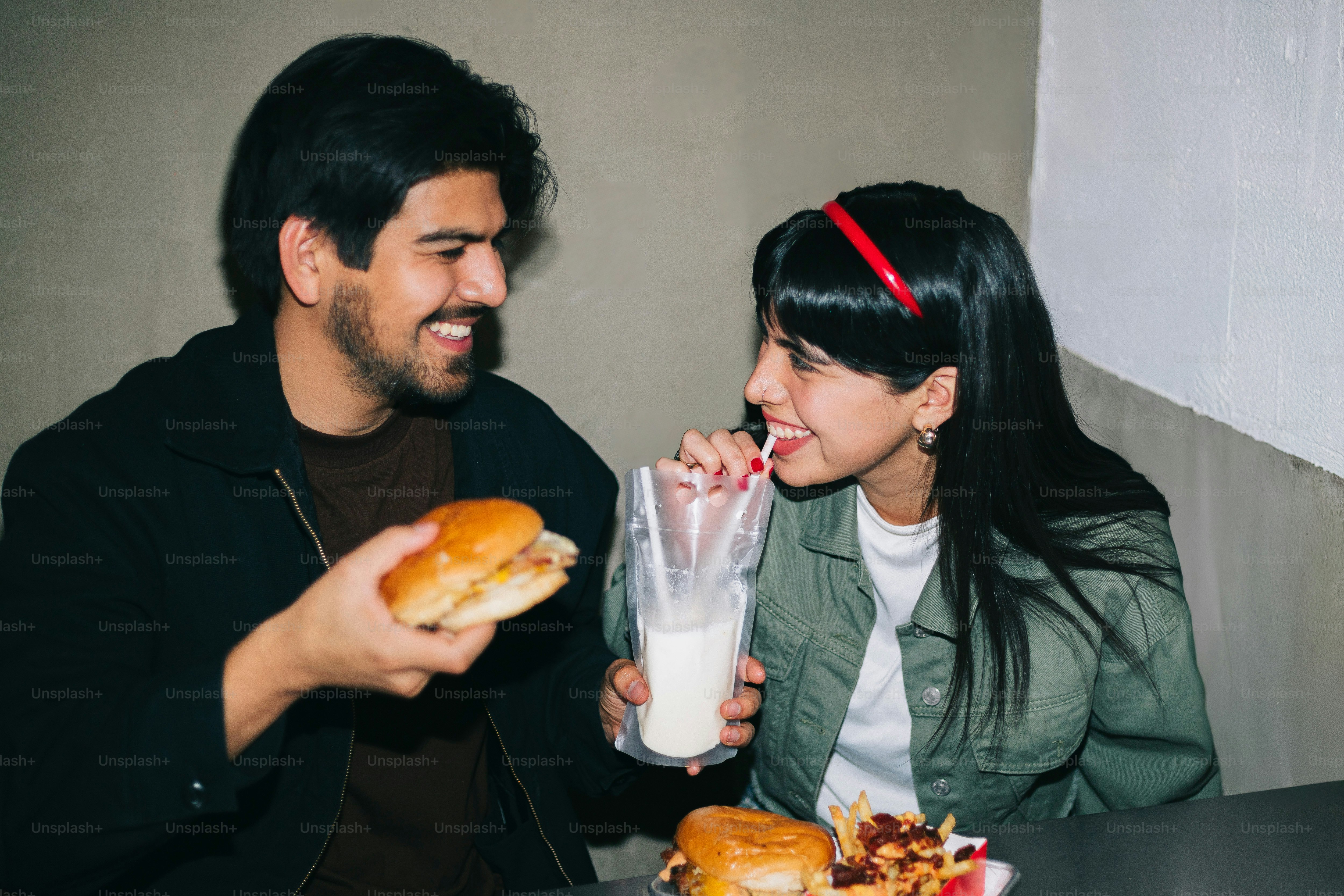 A man and a woman sitting at a table eating food