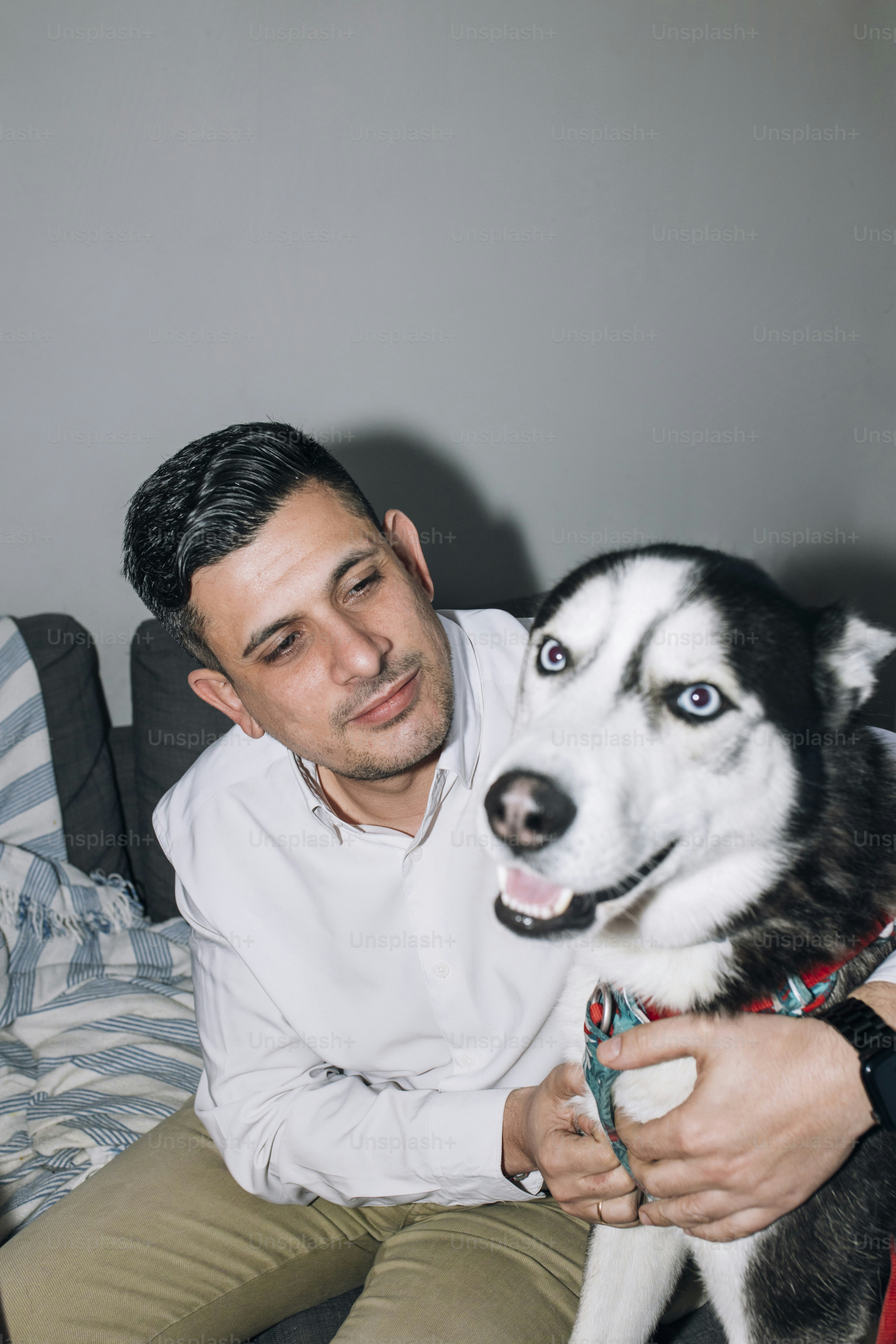 A man sitting on a couch holding a dog