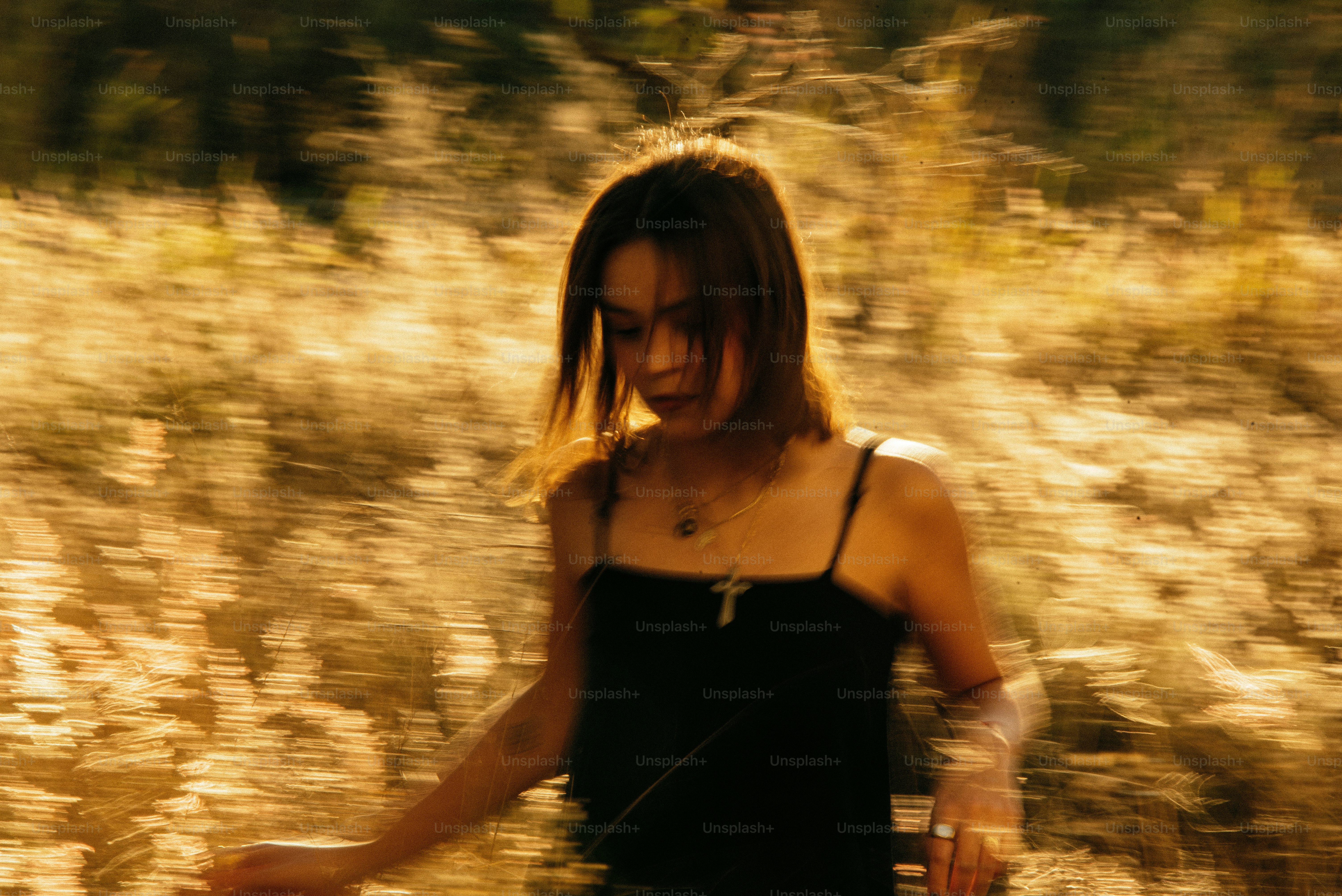 A woman in a black dress walking through a field