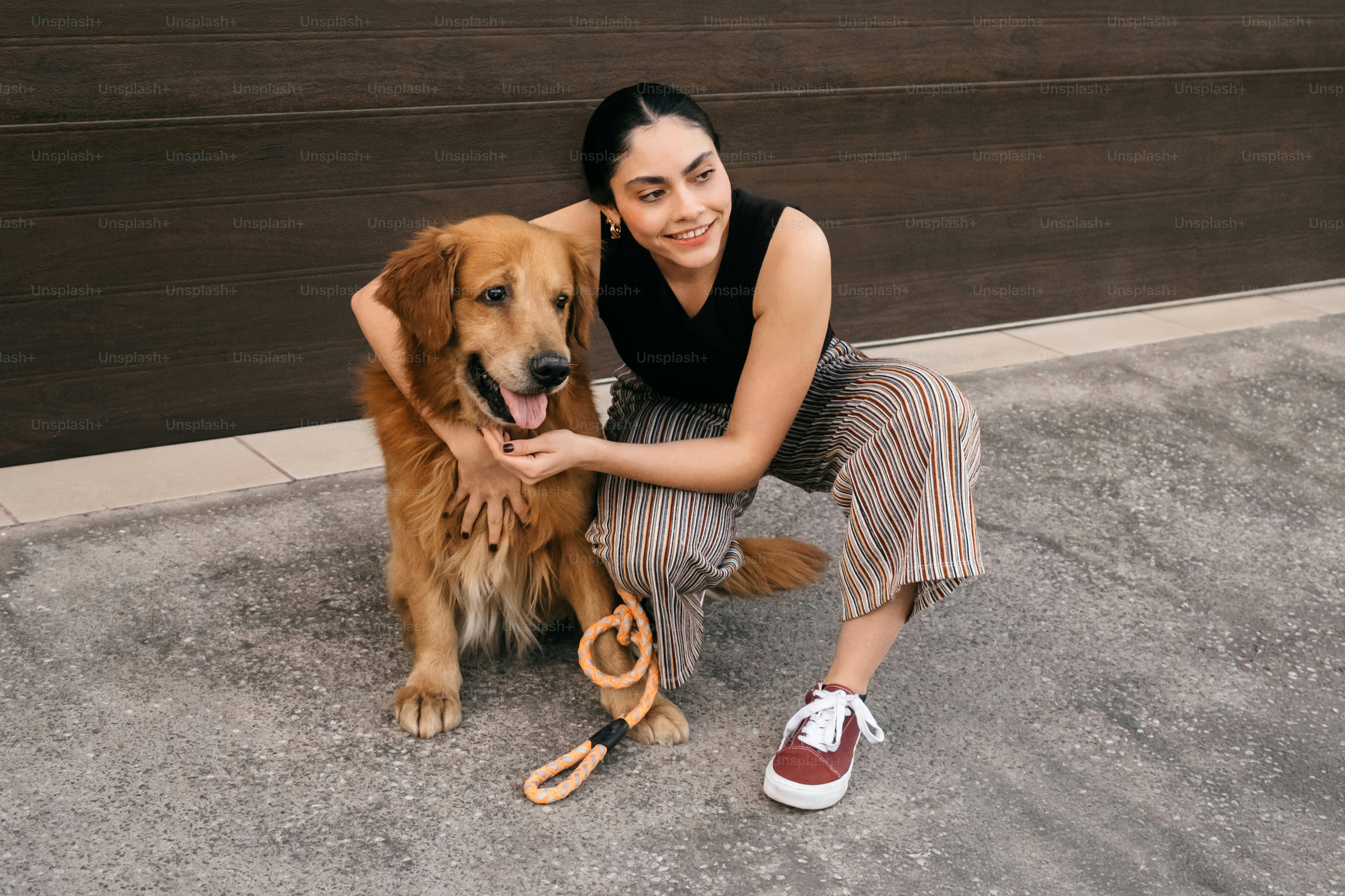 A woman kneeling down next to a brown dog photo – Dog Image on Unsplash
