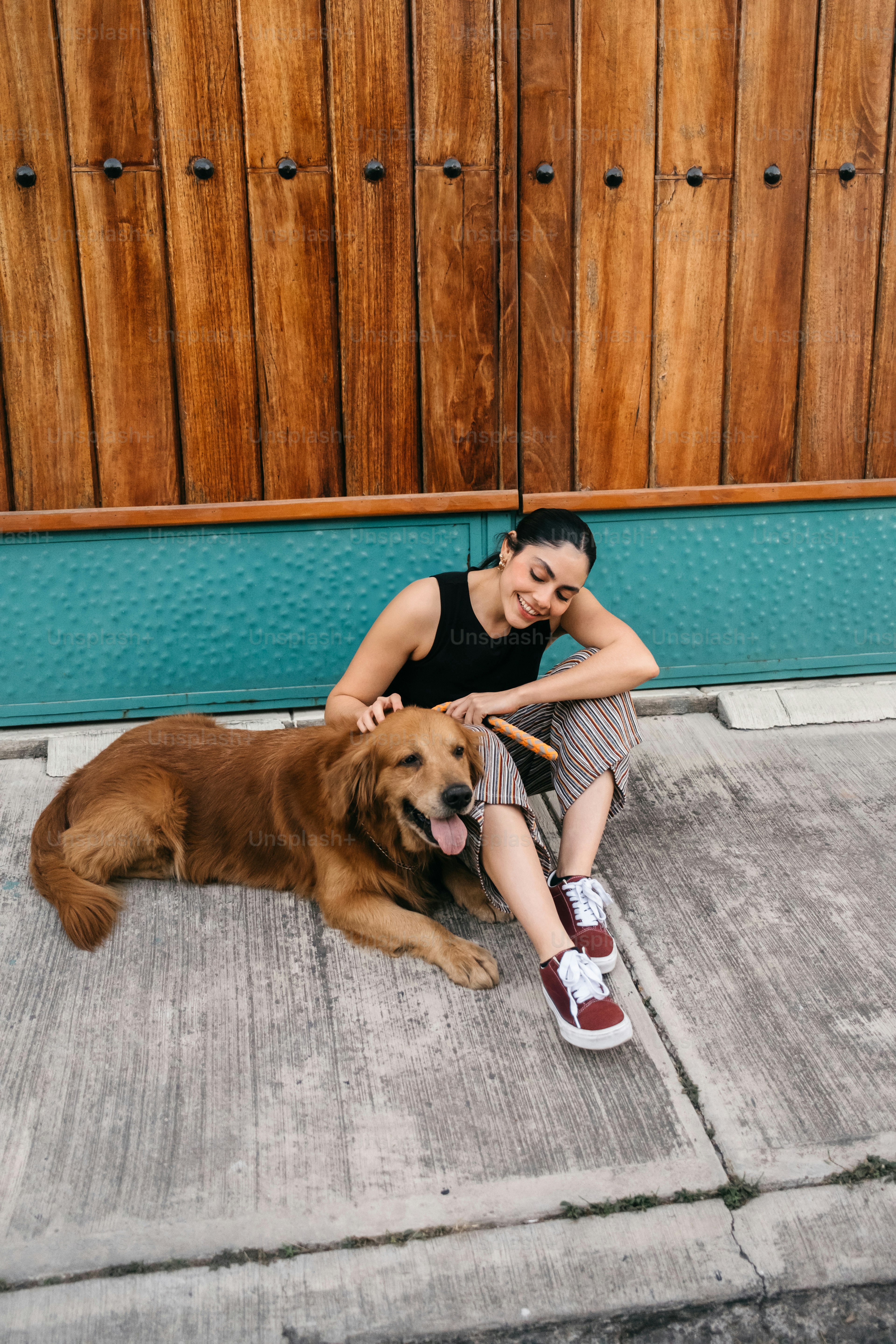 A woman kneeling down next to a brown dog photo – Dog Image on Unsplash